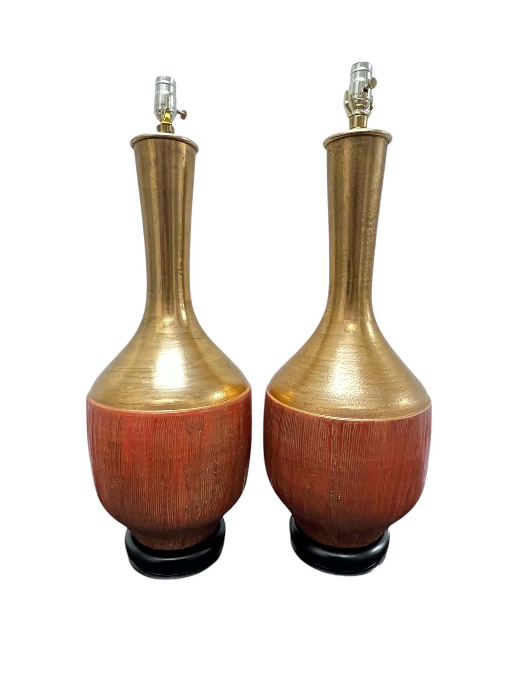 Coppia di lampade da tavolo monumentali di metà secolo in ceramica dorata e terracotta color arancio di Marbro Lamp Co. Nel complesso ottime condizioni vintage con usura appropriata all'età. Le lampade sono state ricablate. Le lampade misurano