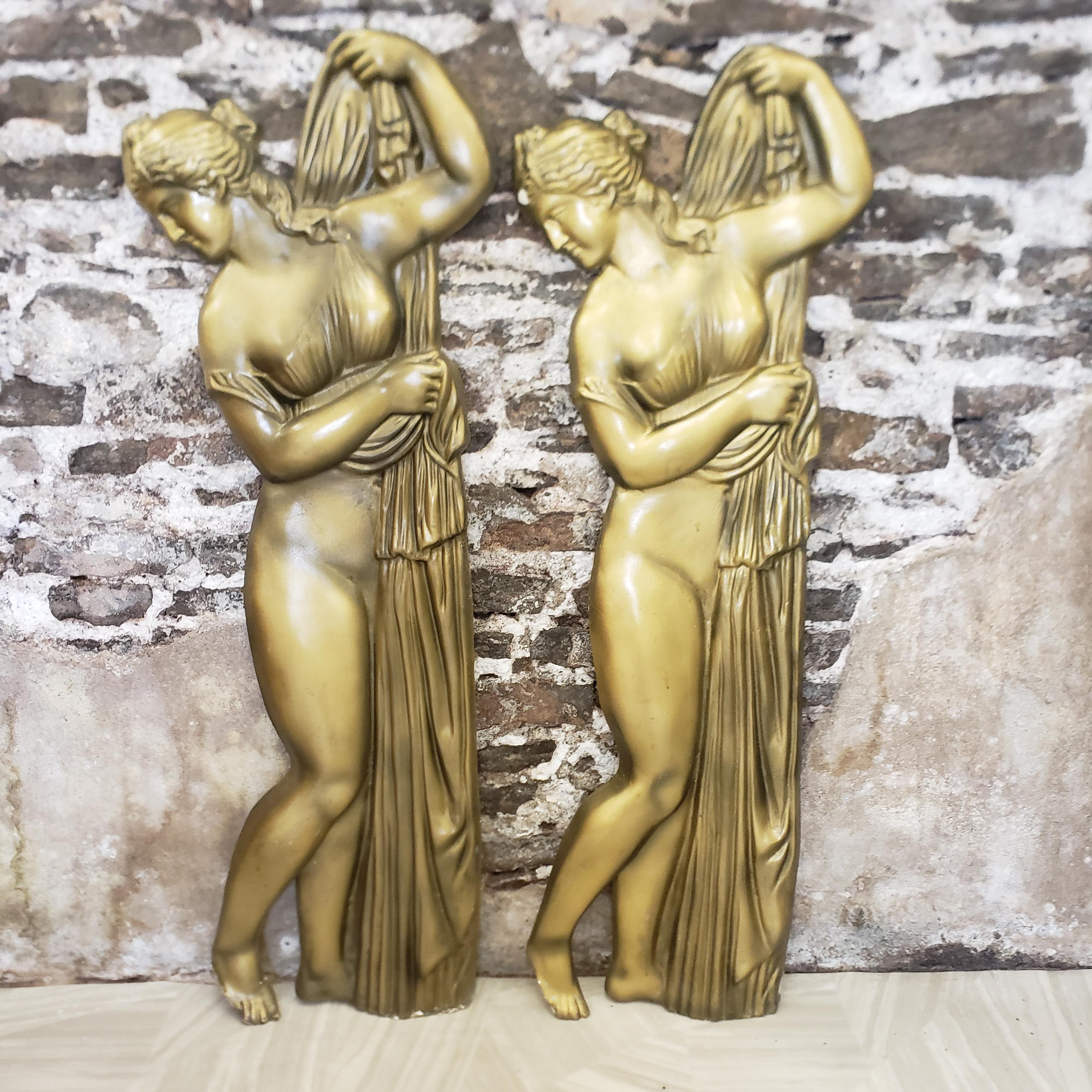 This mid-century era matched pair of molded fiberglass wall sculptures are unsigned, but presumed to have been made in Canada in approximately 1960 in a Neoclassical Revival style. The reliefs depict a pair of seminude young females with long