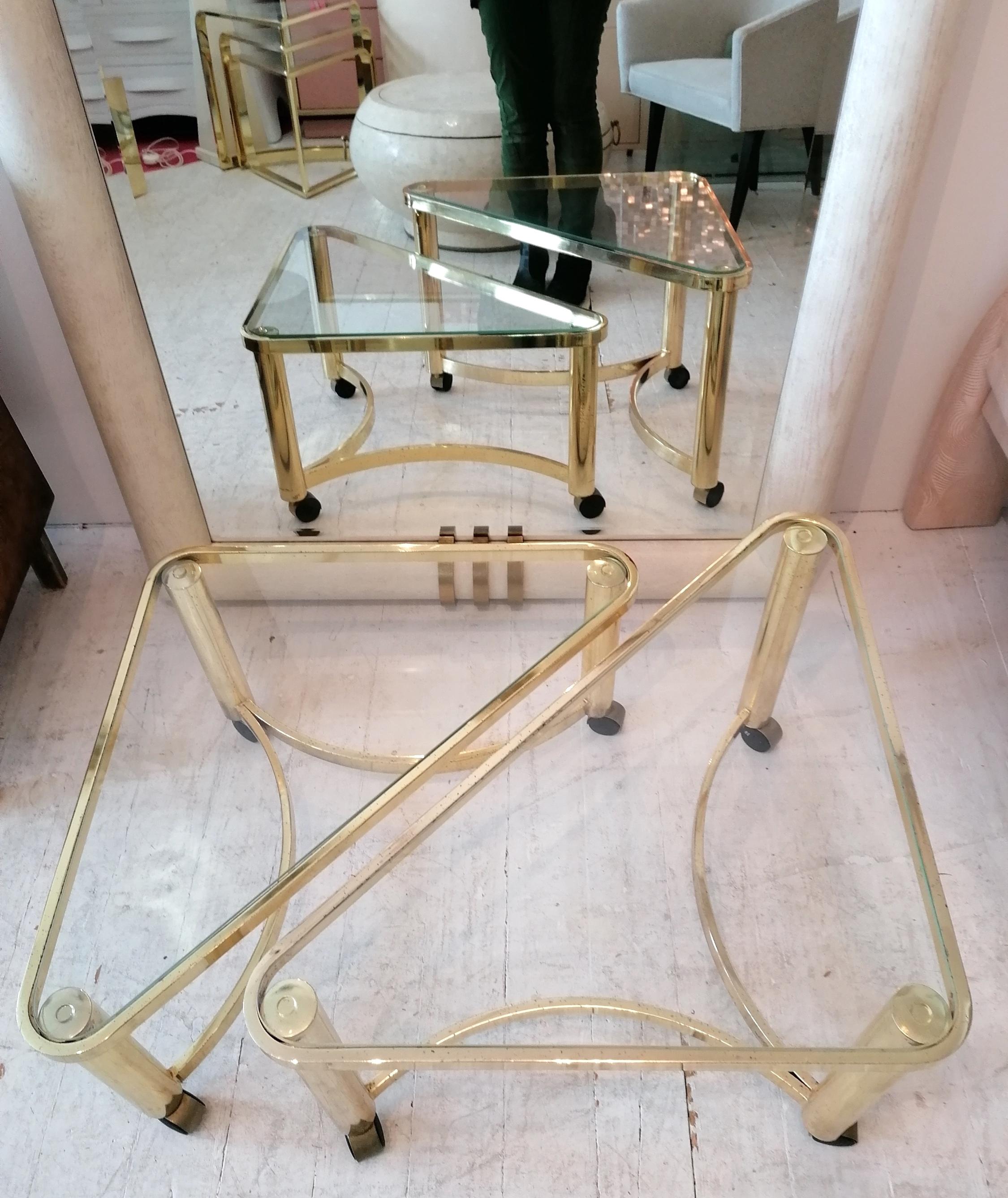 A pair of Postmodern triangular gold-plate metal nesting tables with inset glass tops, on casters, by the prestigious Design Institute of America, USA, 1980s (labelled). These can be used as coffee tables or side tables.

Dimensions:
Large- width