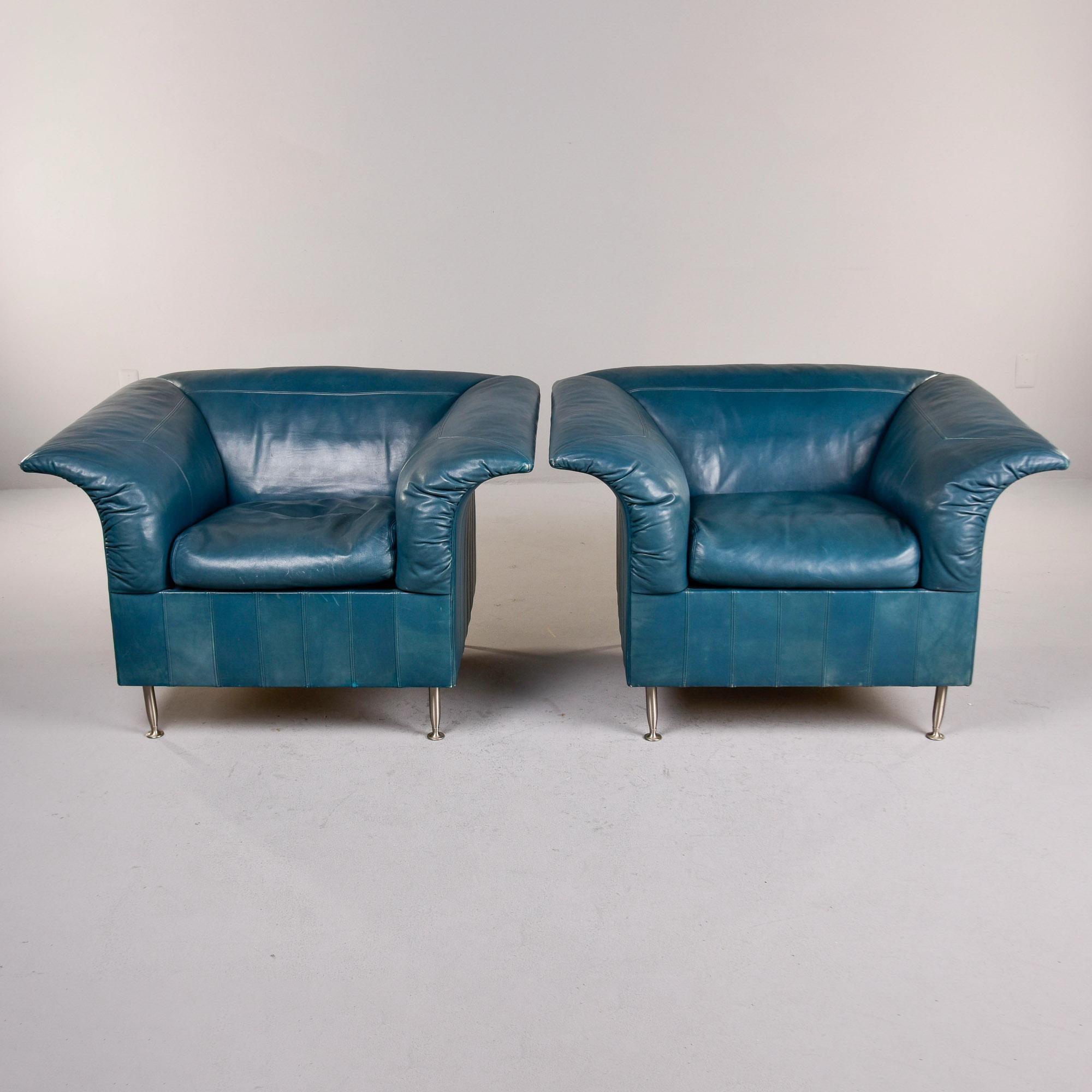 Encontradas en Italia, este par de esculturales sillas revestidas de cuero de Poltrona Frau datan de la década de 1980. Las sillas tienen una forma cubista con brazos dramáticamente acampanados y patas de metal en tono plateado. El cuero verde