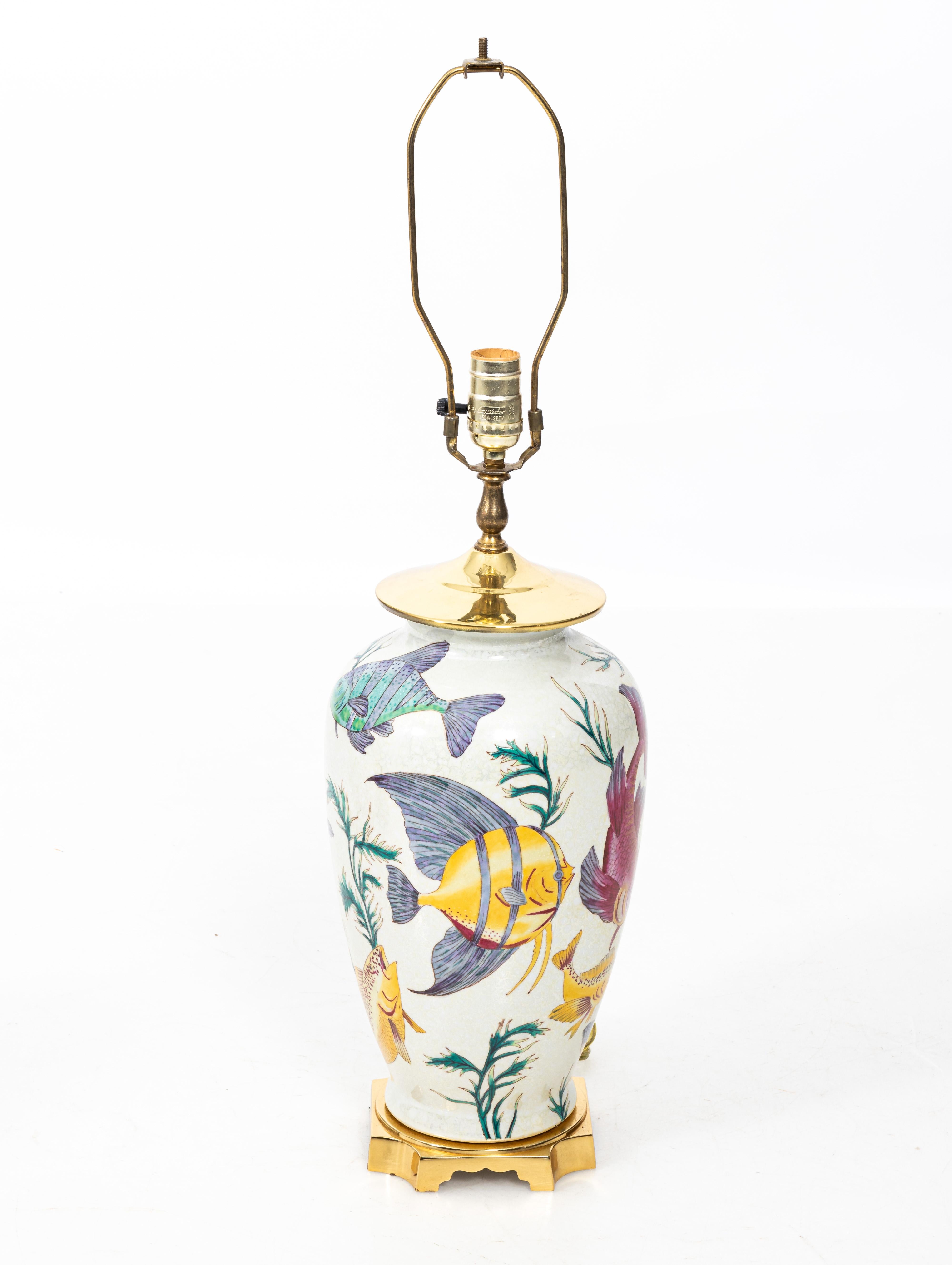 Pair of vintage porcelain crackle glaze fish motif lamps with brass bases.