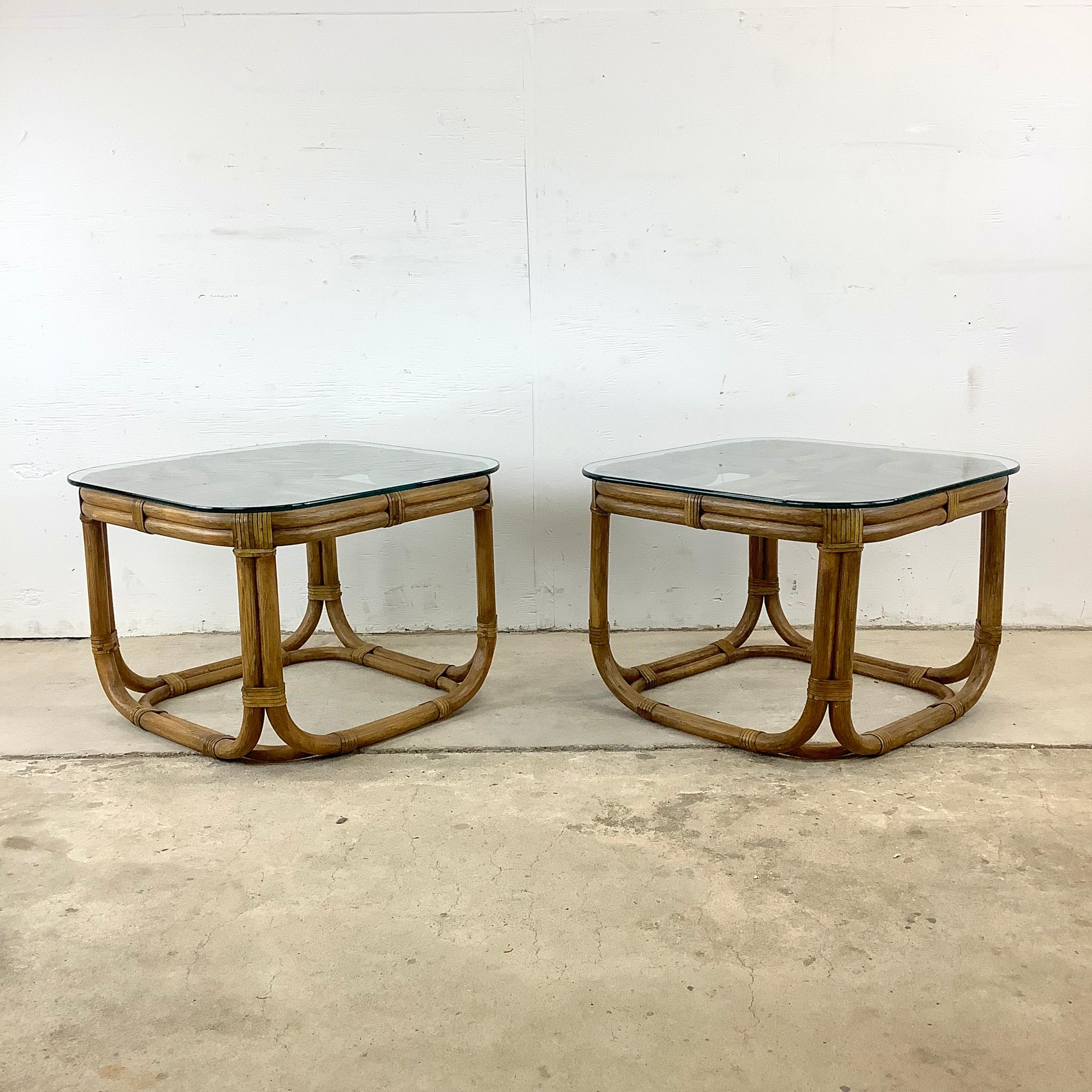 Introducing this pair of vintage square rattan side tables, each crowned with an elegant glass top. These boho chic tables are a testament to the timeless allure of coastal design and the enduring charm of rattan furniture. Perfectly suited for