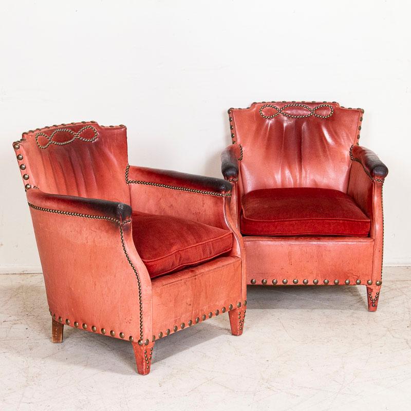 Amazing pair of vintage red leather club or lounge chairs designed by Otto Schultz and produced by Boet of Goteburg, Sweden. The notable use of nail heads as decoration were one of Schultz's style statements, yet it is the unique red leather faded
