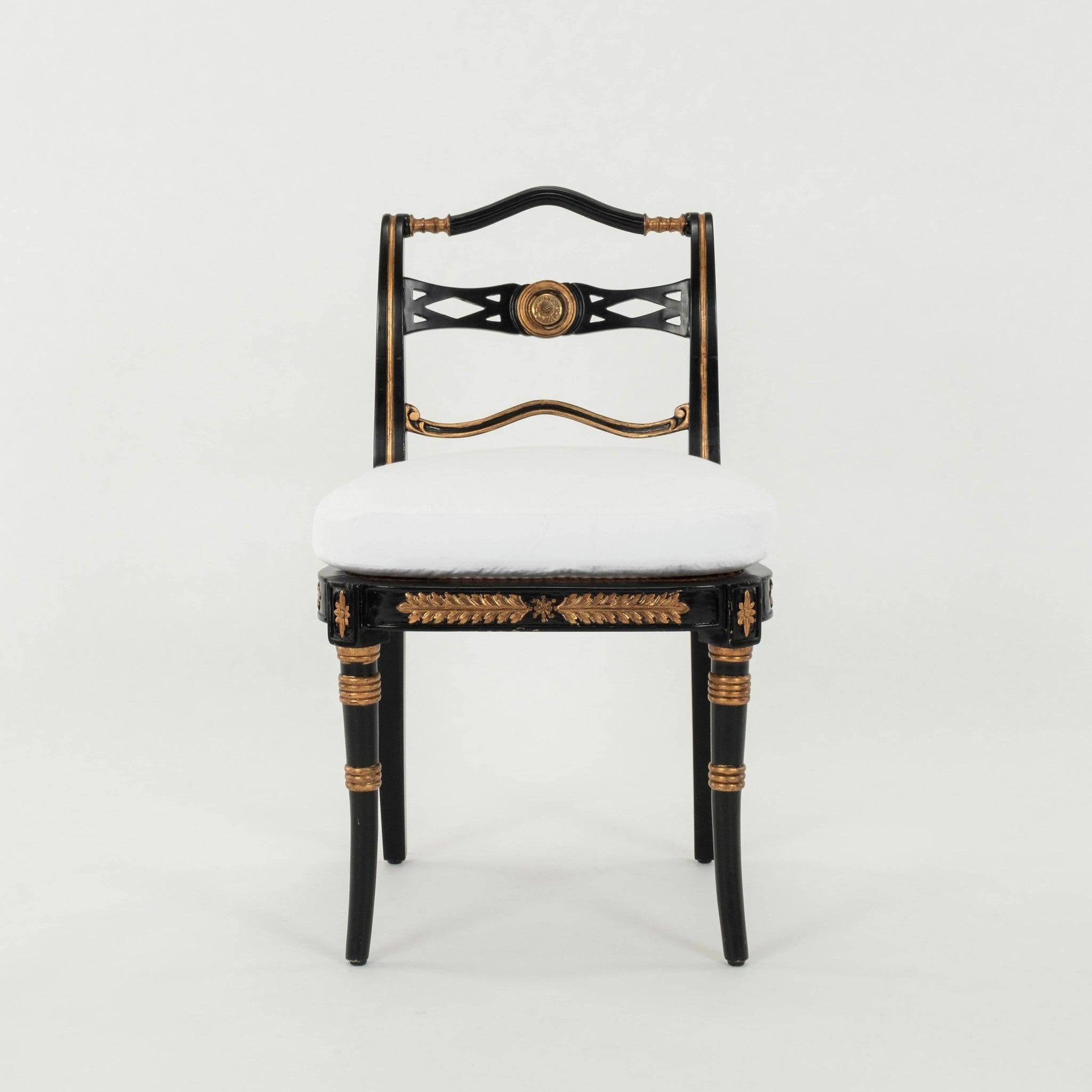 Coppia di sedie in stile Regency degli anni '60 con struttura in legno verniciato nero oro, seduta in canna e cuscino della seduta bianco appena imbottito.