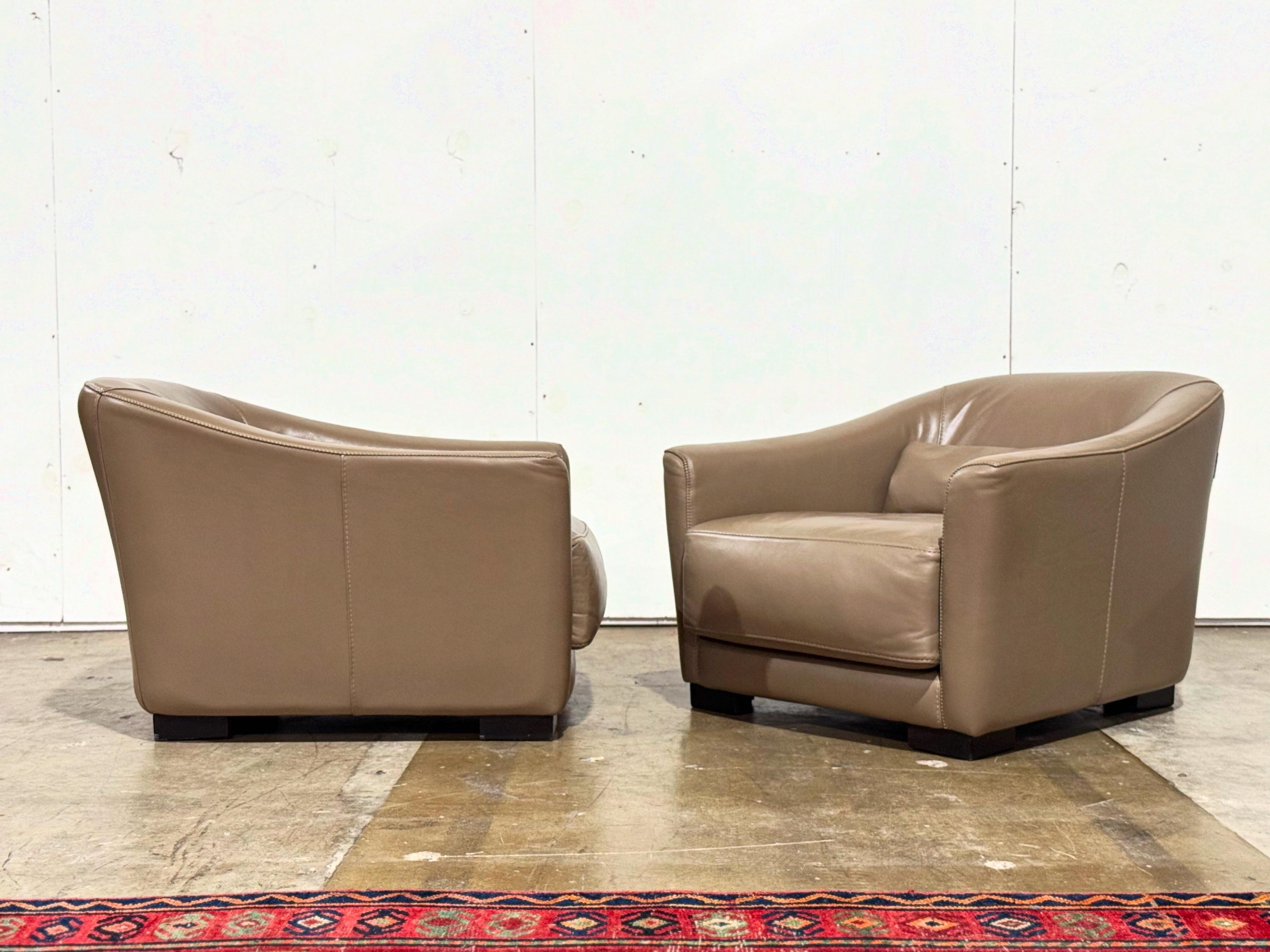 Exquisite pair of low slung streamlined moderne or art deco style leather lounge chairs by Roche Bobois, France circa early 2000s. Striking silhouette and opulent comfort. The full grain grey leather has aged to perfection. These chairs are unique