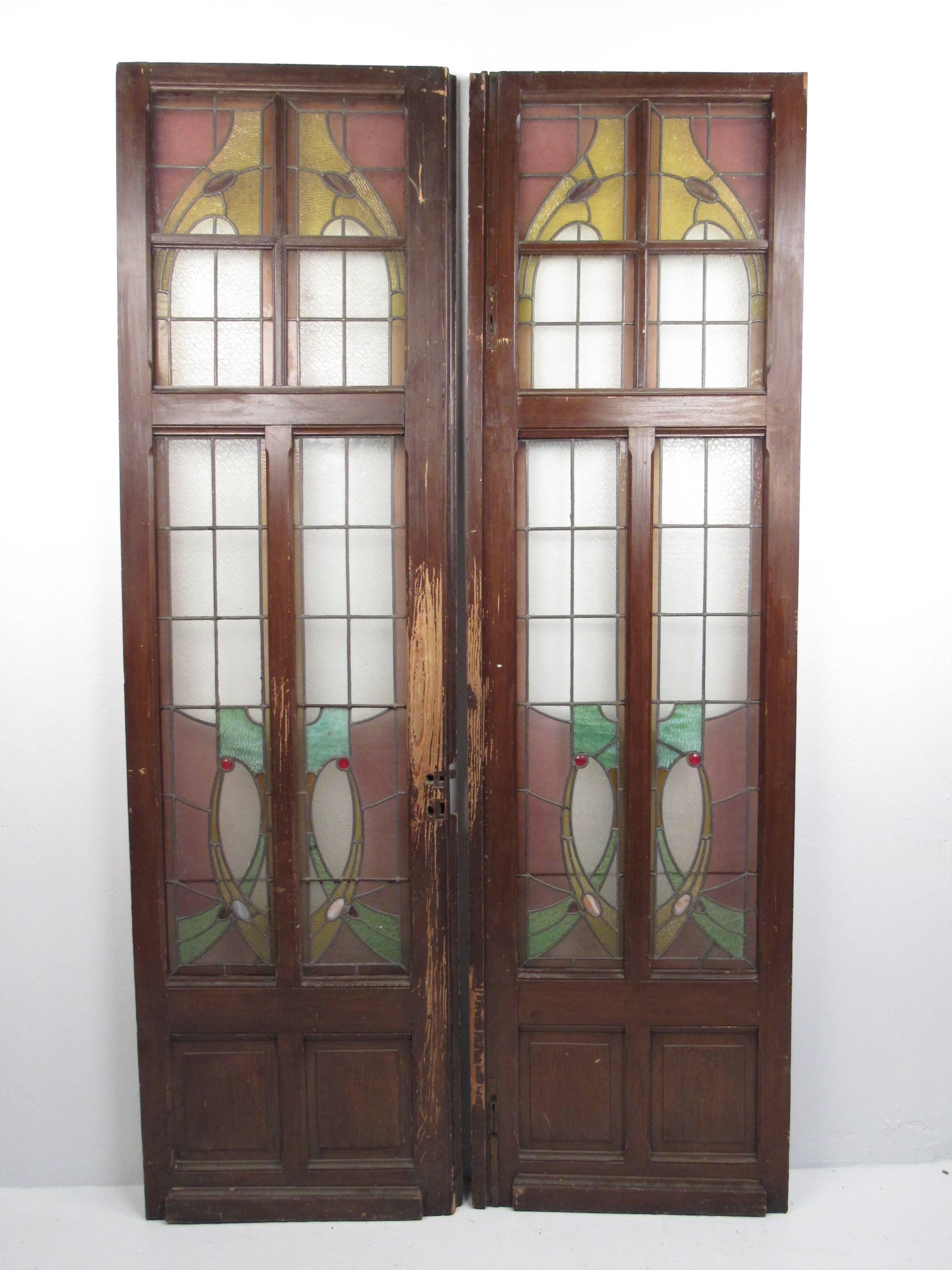 This exquisite matched pair of stained glass doors features hardwood frames with beautiful stained glass window panes. Perfect antique stained glass entry doors for home or shop use or display. Please confirm item location (NY or NJ).