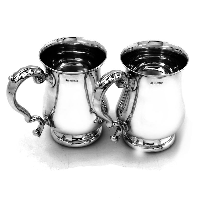 An excellent pair of vintage solid Silver Pint Beer Mugs in the traditional Georgian style with baluster shaped bodies and acanthus leaf topped scroll handle. Each Mug has the elegant, understated design that so typifies the Georgian style, and each