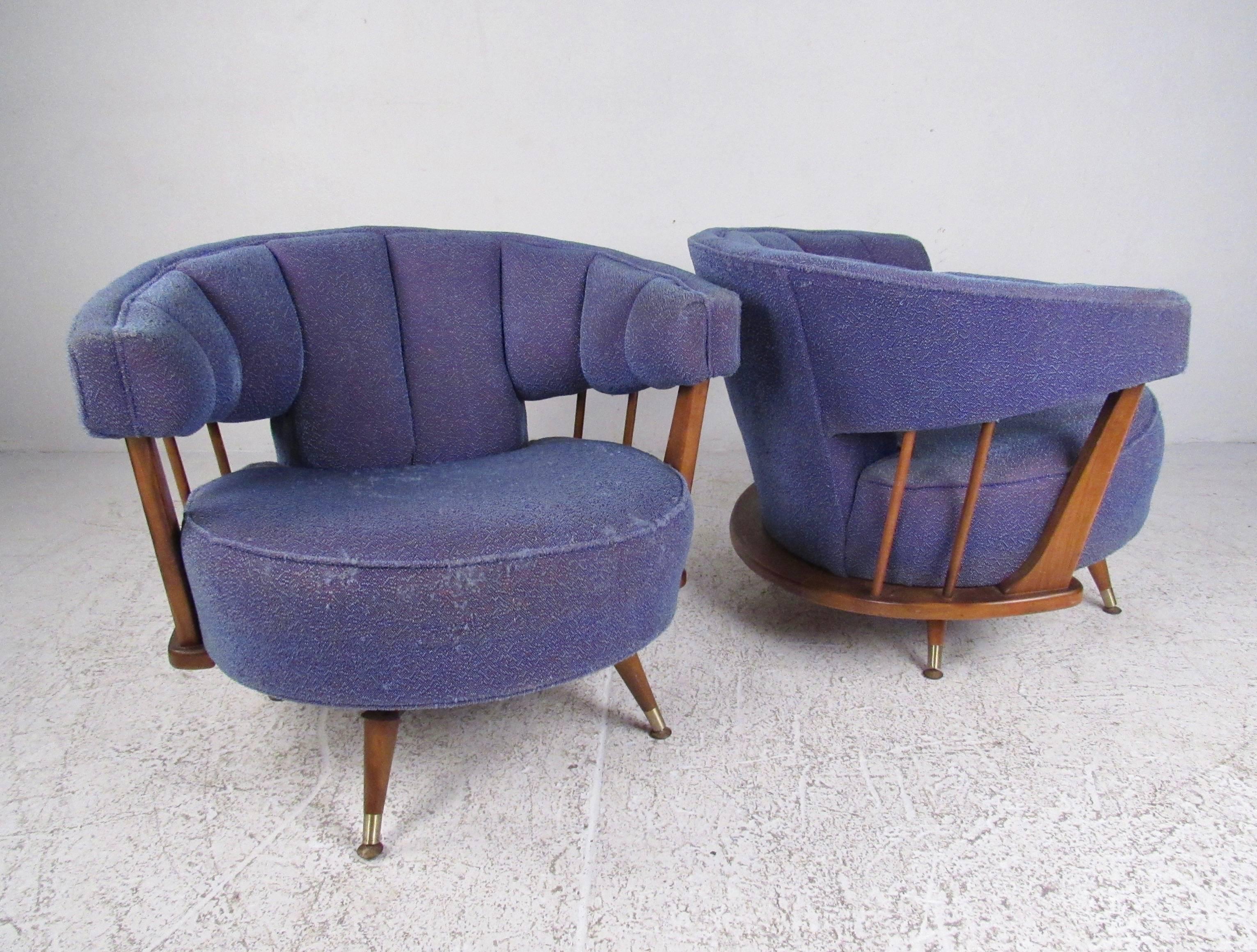 This stylish pair of Danish modern chairs feature walnut swivel frames, barrel back seats, and tapered legs with brass sabots. Unique mid-century style makes these vintage lounge chairs the perfect addition for home or business seating. Please