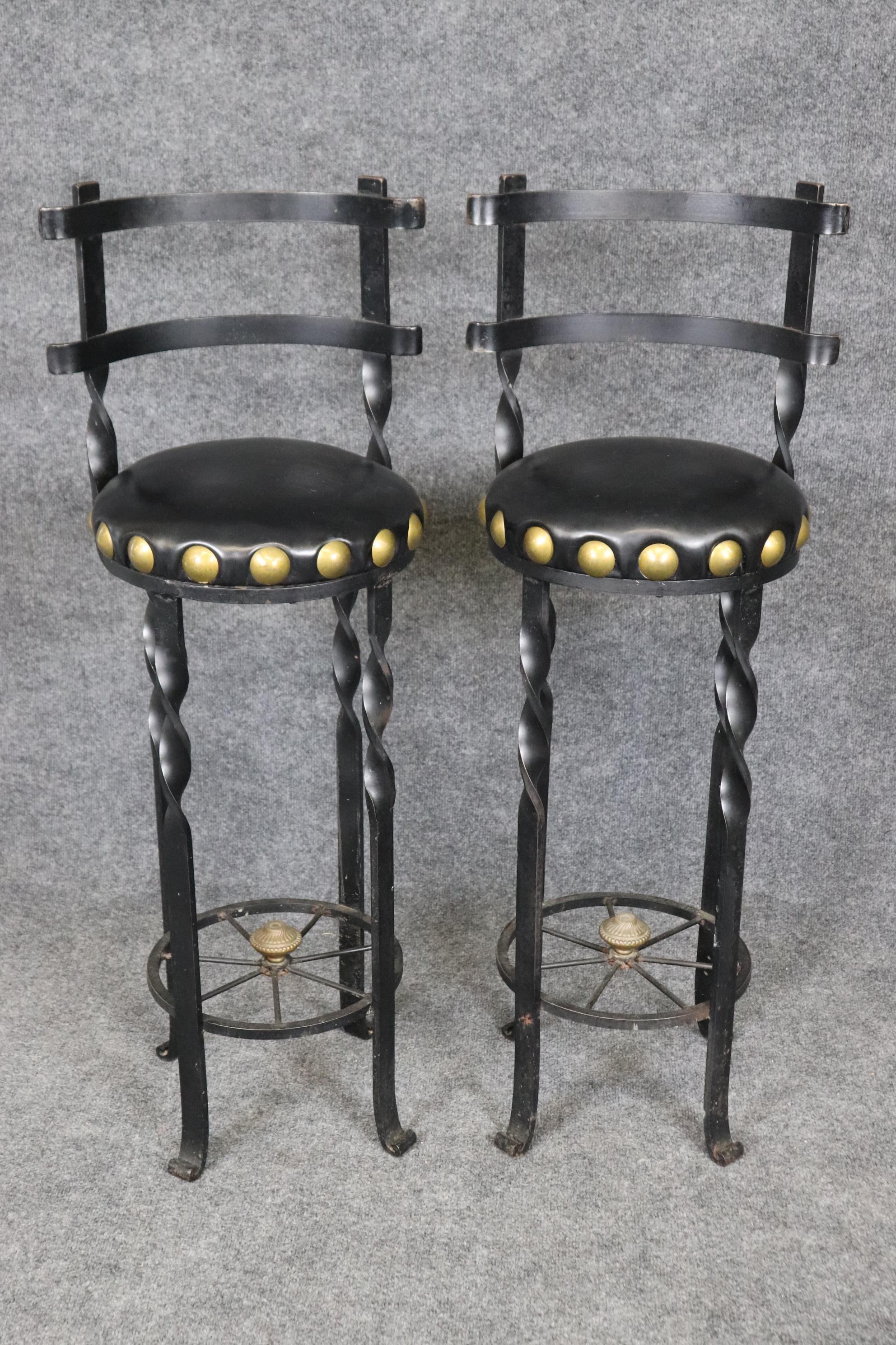 Cette paire unique de tabourets de bar de style espagnol est parfaite pour votre bar de style hacienda espagnole en Californie du Sud ou pour un airbnb en Europe. Ils sont en bon état, avec des sièges en vinyle et d'énormes clous en laiton de la