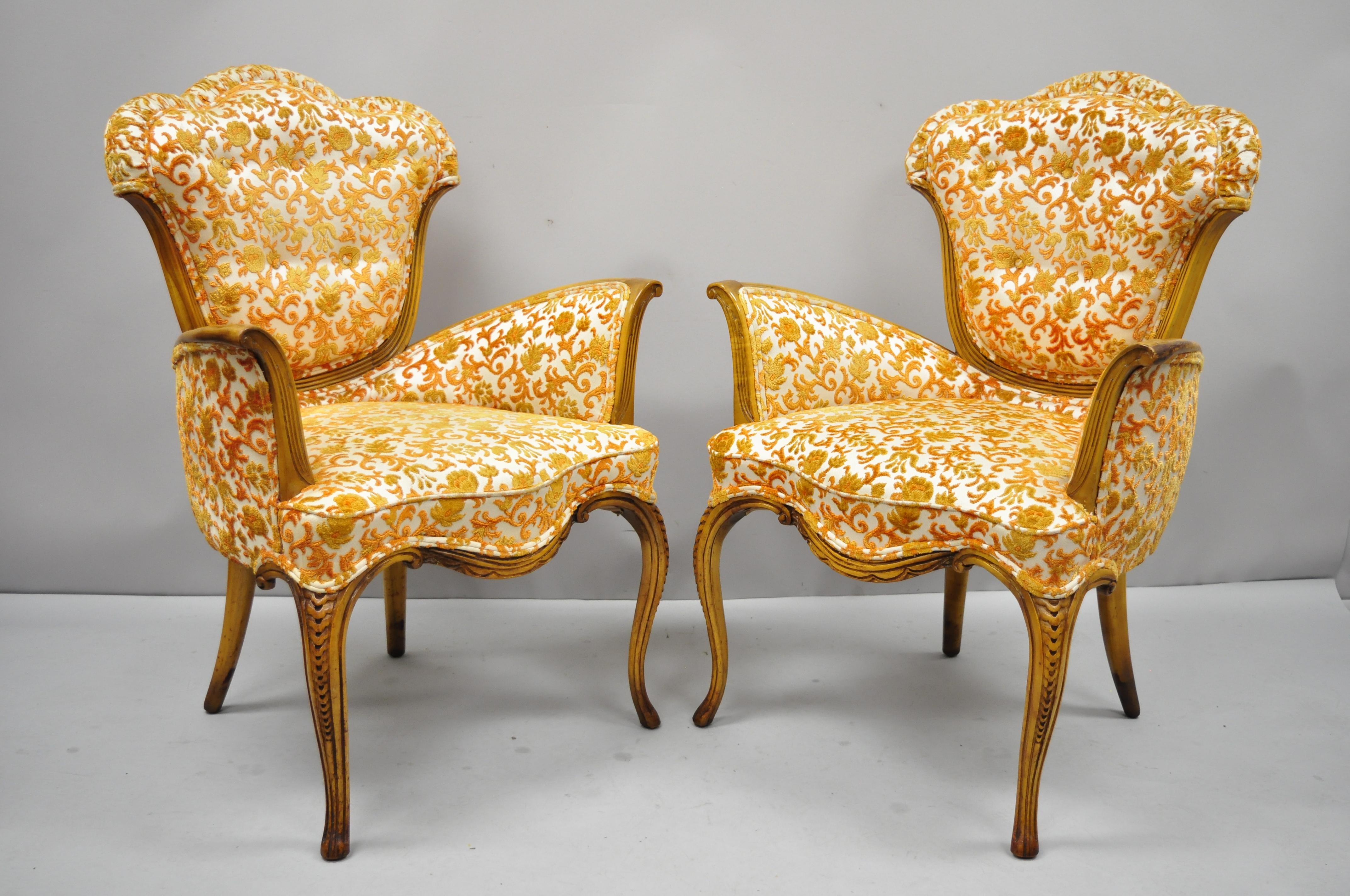 Pair of vintage Hollywood Regency French style orange fabric fireside lounge armchairs. Item features ornate orange floral print fabric, thick tufted backs, solid wood frame, nicely carved details, tapered legs, very nice vintage item, great style