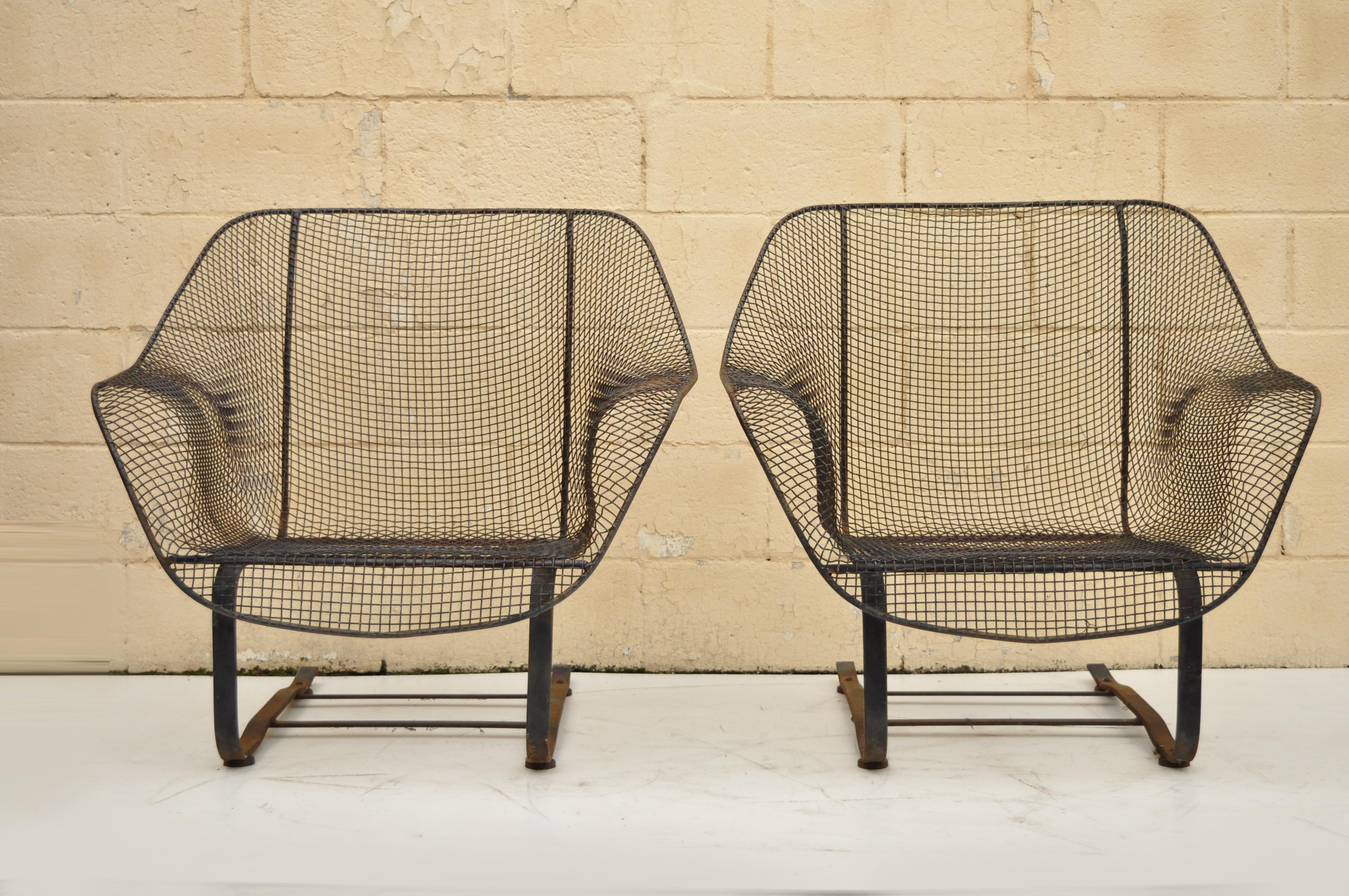 Pair of vintage Russell Woodard sculptura metal mesh wrought iron Bouncer lounge chairs. Items feature iron frame, metal mesh seats, iconic mid-century modern design, very nice vintage item, circa 1950. Measurements: 32