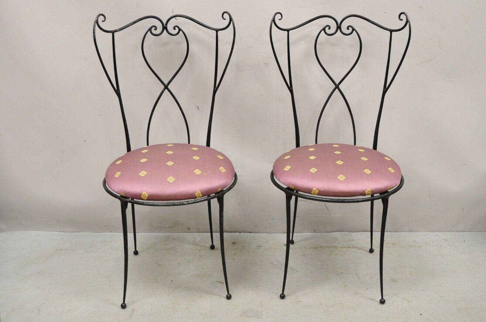 Pair vintage Salterini style Mid-Century Modern wrought iron scrolling side chairs. Item features shapely saber legs, curved backs, wrought iron construction, very nice vintage pair, quality craftsmanship, sleek sculptural form, maker unconfirmed