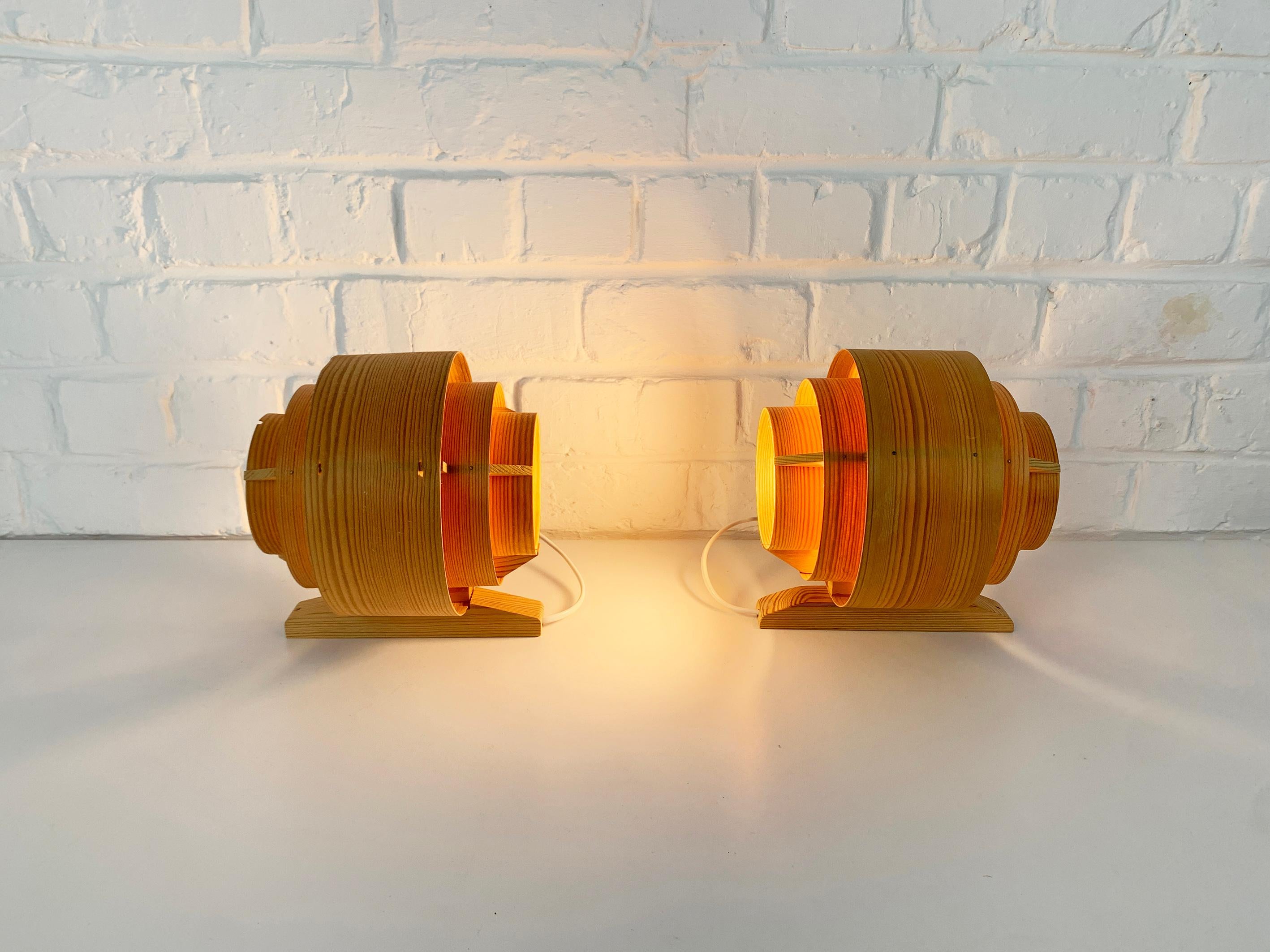 Lampade da parete in legno di pino modello V327 di Hans-Agne Jakobsson. Prodotto da AB Ellysett in Svezia.

Le applique sono composte da strisce di impiallacciatura di pino, piegate ad anello e fissate su una cornice di legno di pino. Un'altra parte