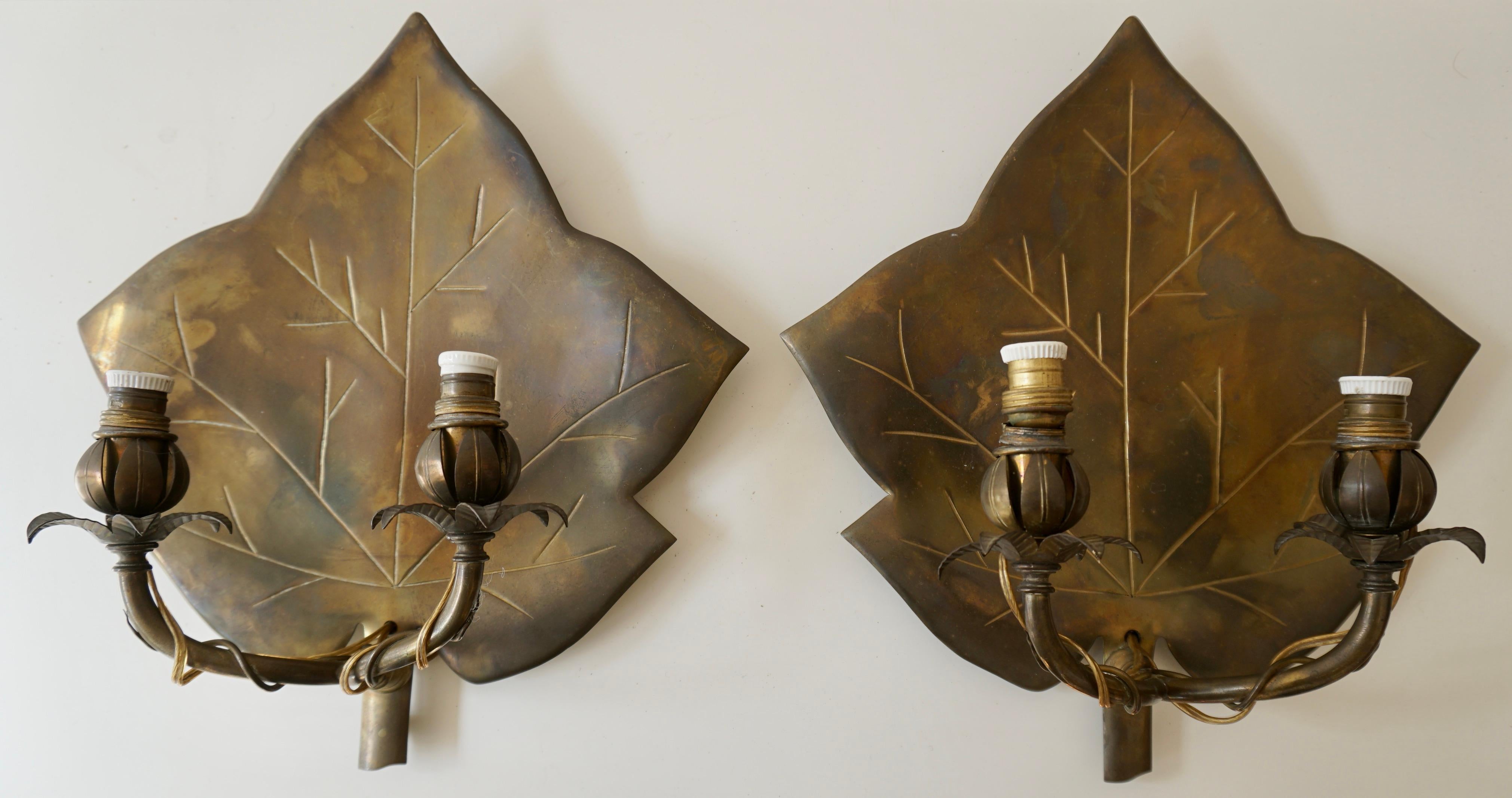 Wall sconces, per pair, first half 20th century.
Brass wall sconces in the shape of leaves. Two curved candle arms for one lamp each. 



