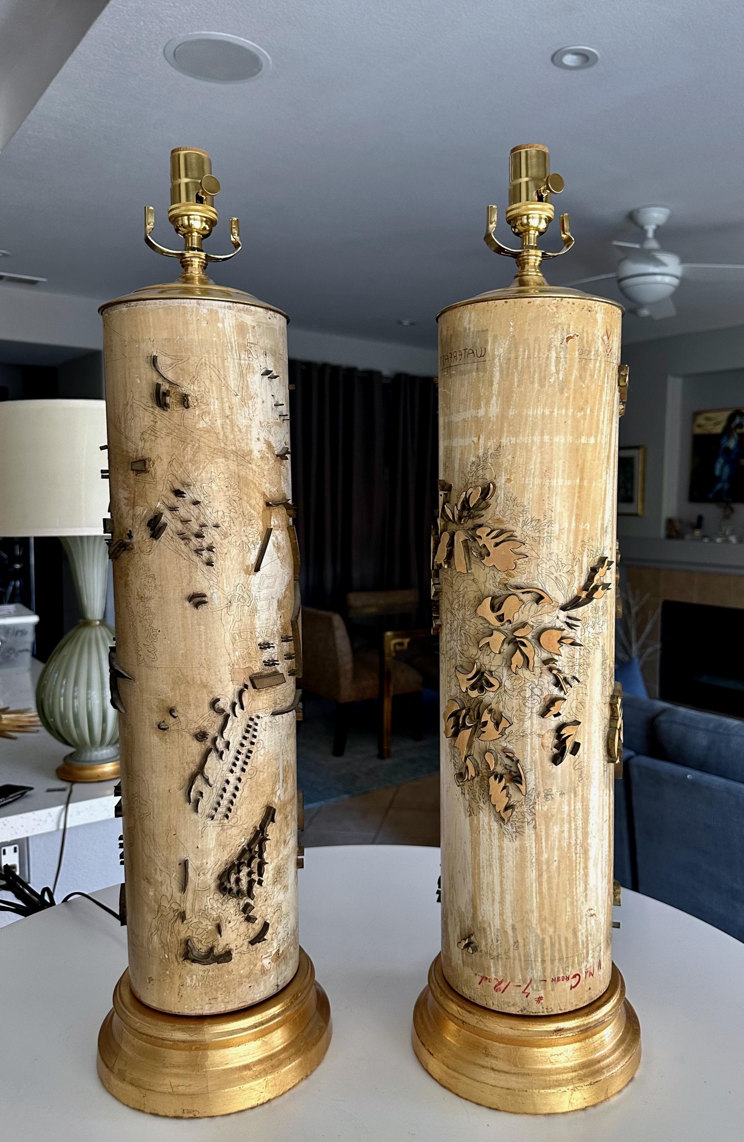 Paire de rouleaux de papier peint vintage à grande échelle des années 1930 en guise de lampes. Forme cylindrique en bois dur lourd, décorée de motifs en métal massif imprimés. Montés sur des socles en métal doré. Nouveau câblage pour les États-Unis