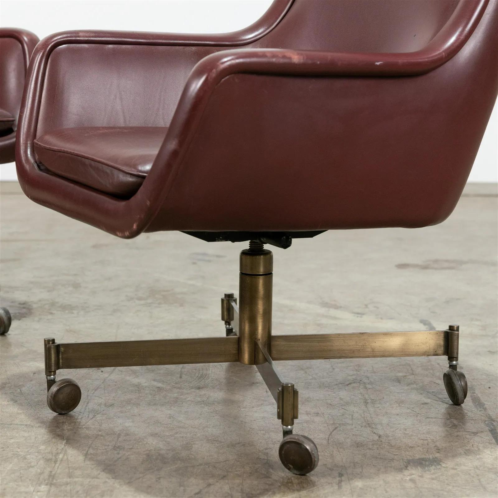 Pair Ward Bennett leather chairs for Brickell Associates. The chairs are leather with a metal bronzed finish base and four casters.
