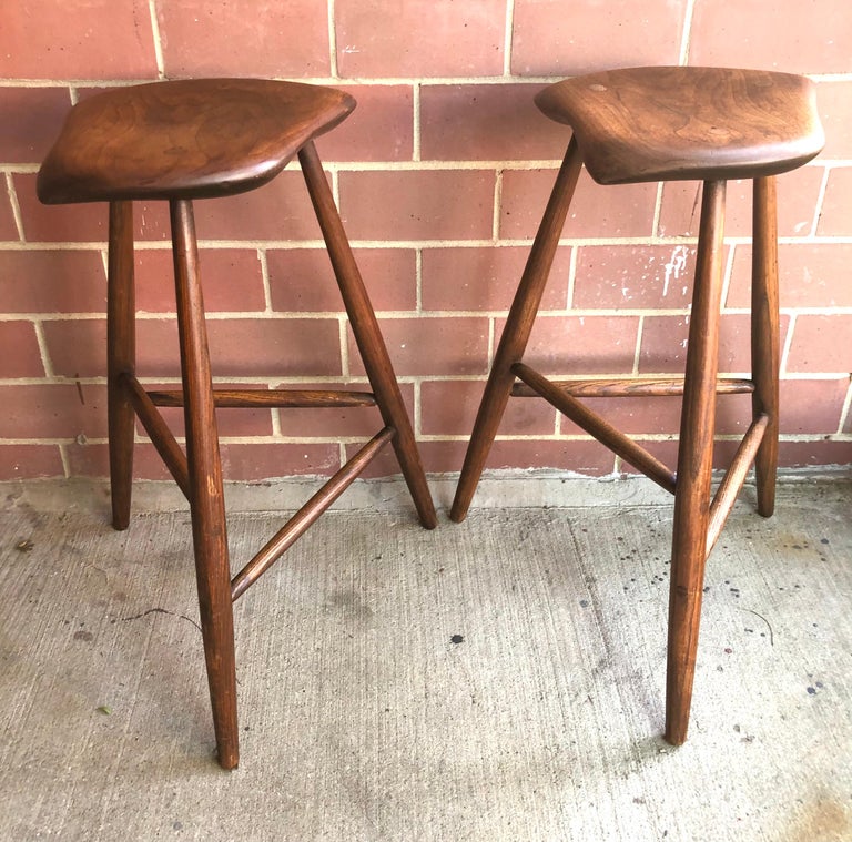 c. 1950s/60s, biomorphic carved walnut or redgum seat on three hickory legs joined by staggered dowels, all mortise and tenon construction with exposed tenon joints on legs and seat. These were built as a true pair from the same piece of walnut,