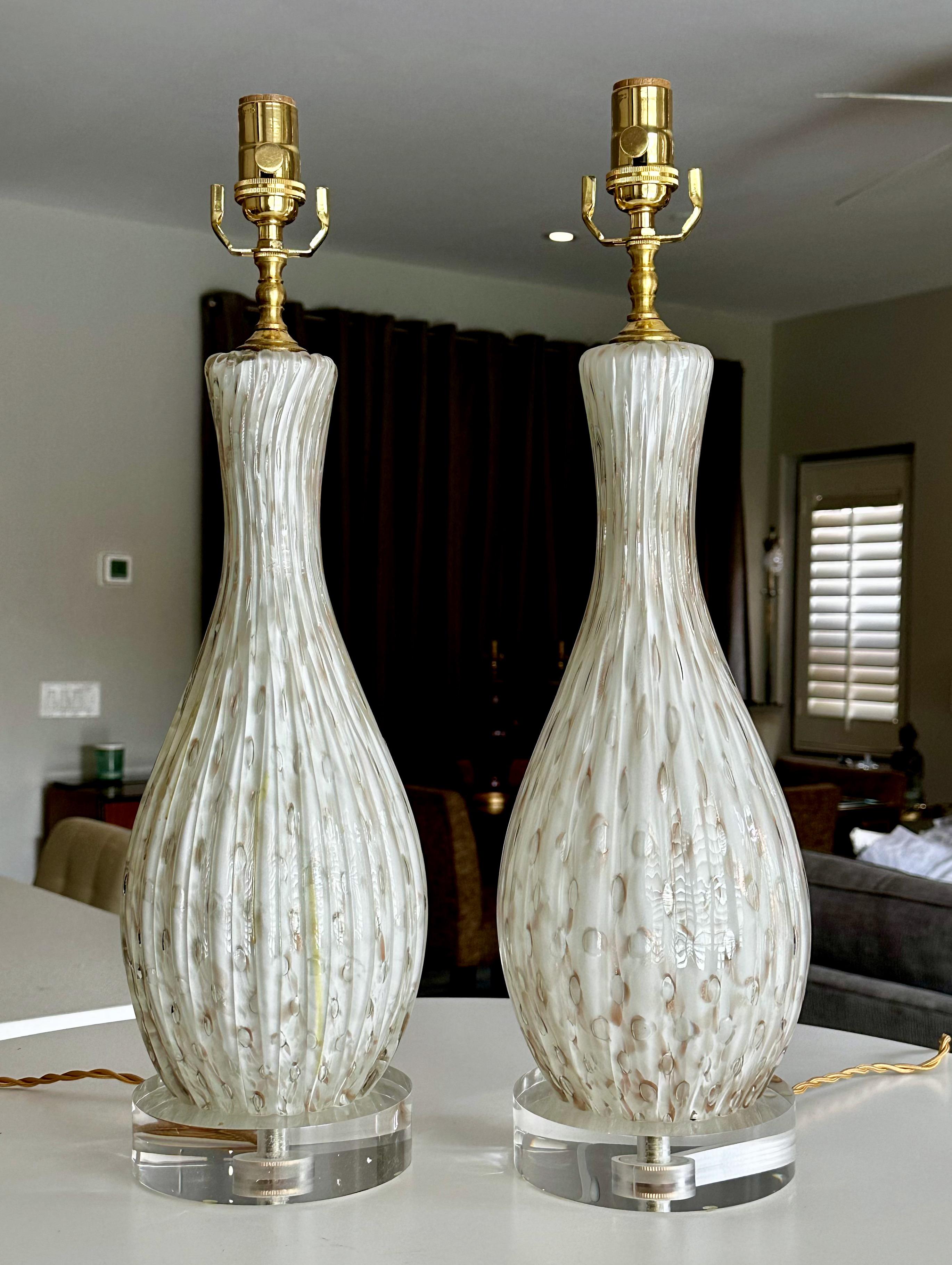 Pair hand blown cased white ribbed Murano Italian glass lamps with copper aventurine inclusions and controlled bubbles throughout. New custom acrylic bases and new polished brass fittings and cords. Newly Rewired.
Overall height top of socket