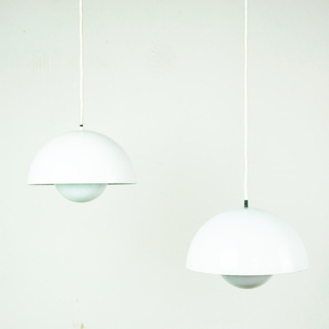 This iconic Danish design classic,  the white metal pendant called Flowerpot was designed by Verner panton in the 1960s for Louis Poulsen.  It is made of thick enamel metal and has an orange reflector which provides a beautiful warm light. Each lamp