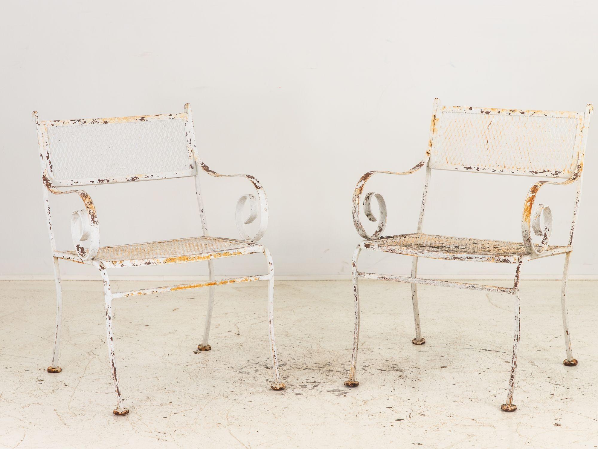 Dieses Paar weiß lackierter Eisenstühle wurde in der pulsierenden Ära der 1950er Jahre in Amerika gefertigt und verkörpert klassische Eleganz und dauerhaften Stil. Mit anmutig geschwungenen Armen und gespreizten Beinen strahlen sie Raffinesse aus,