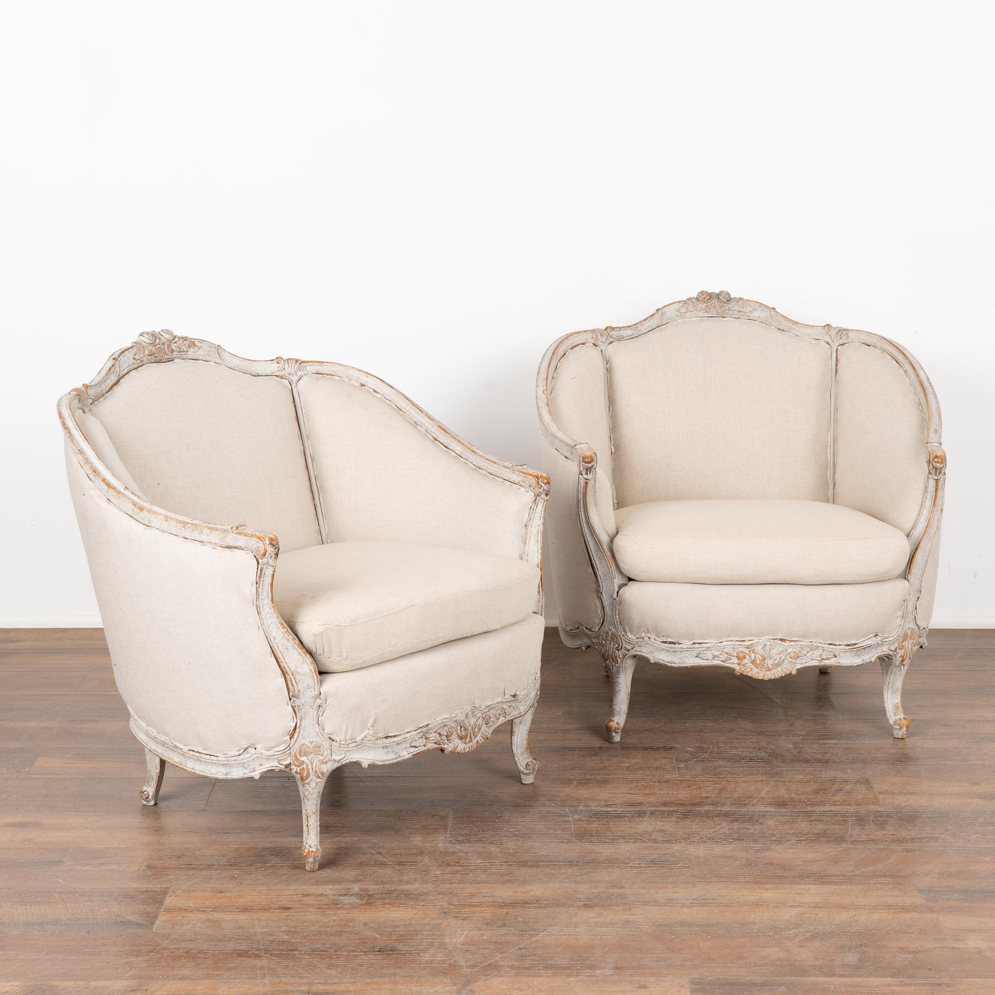 This pair of Swedish arm chairs have a gently curved barrel back, cabriolet legs and decorative carving embellish the skirt which all add to the graceful appeal of each.
The newer professionally applied white layered painted finish has been gently