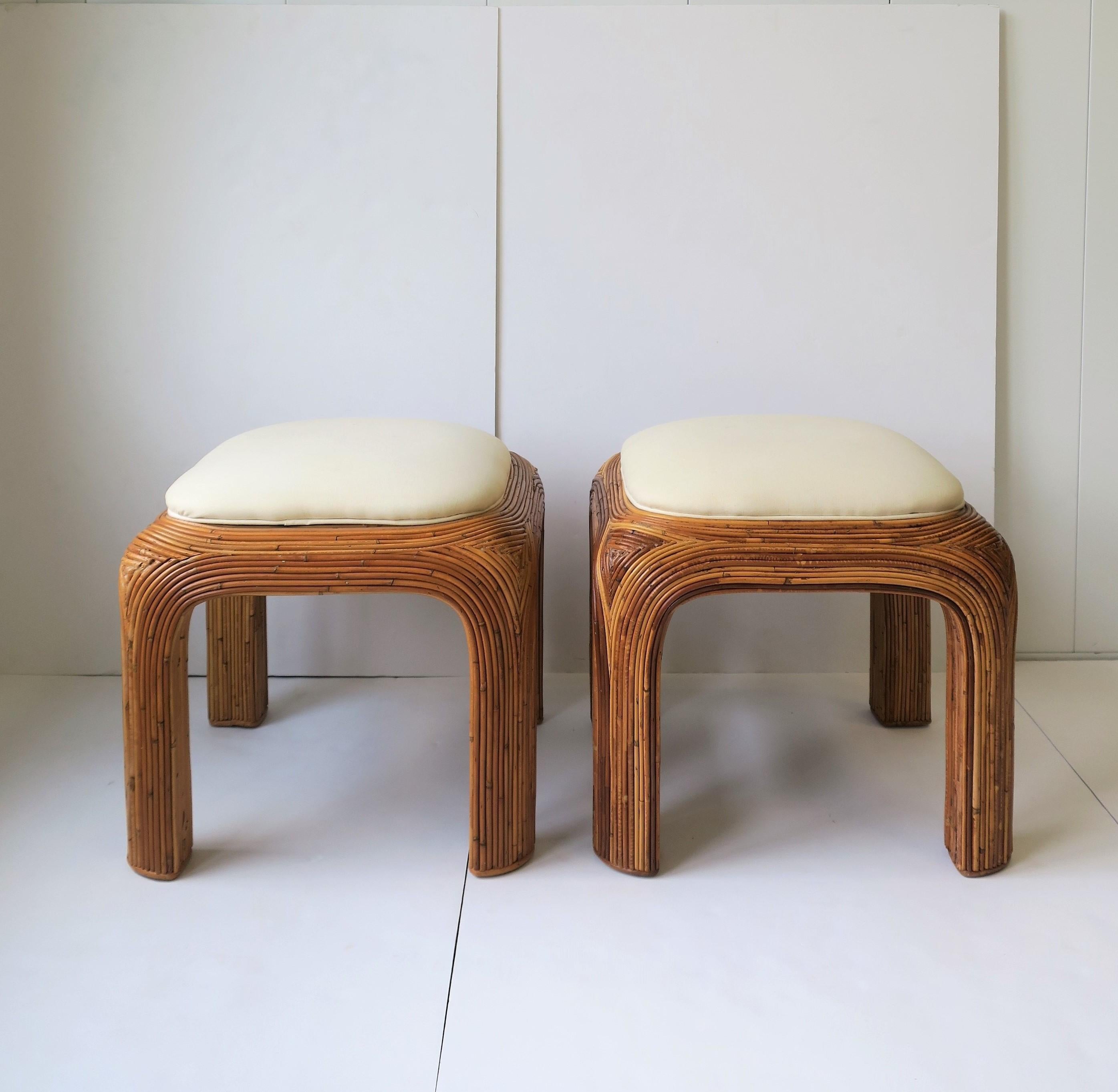A pair of Modern style or Post Modern period wicker pencil reed upholstered stools or benches with cream/ off-white/ beige colored seats, in the style of Italian designer, Gabriella Crespi, circa late 1970s-1980s.

Measurements: 18