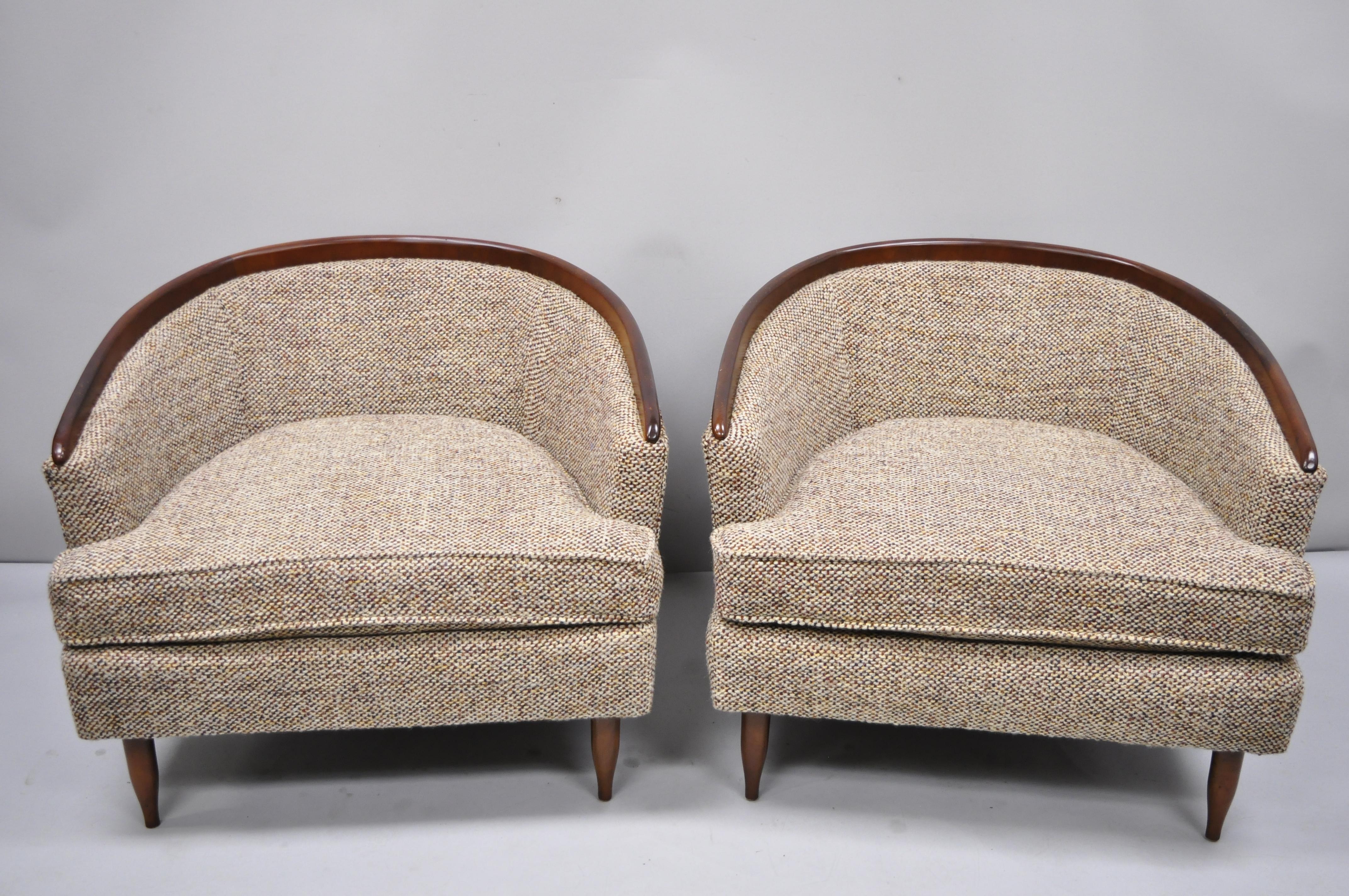Pair of vintage wide barrel back walnut Mid-Century Modern club lounge chairs after Milo Baughman. Item features wide substantial form, wood trim to backs, wooden tapered legs, 