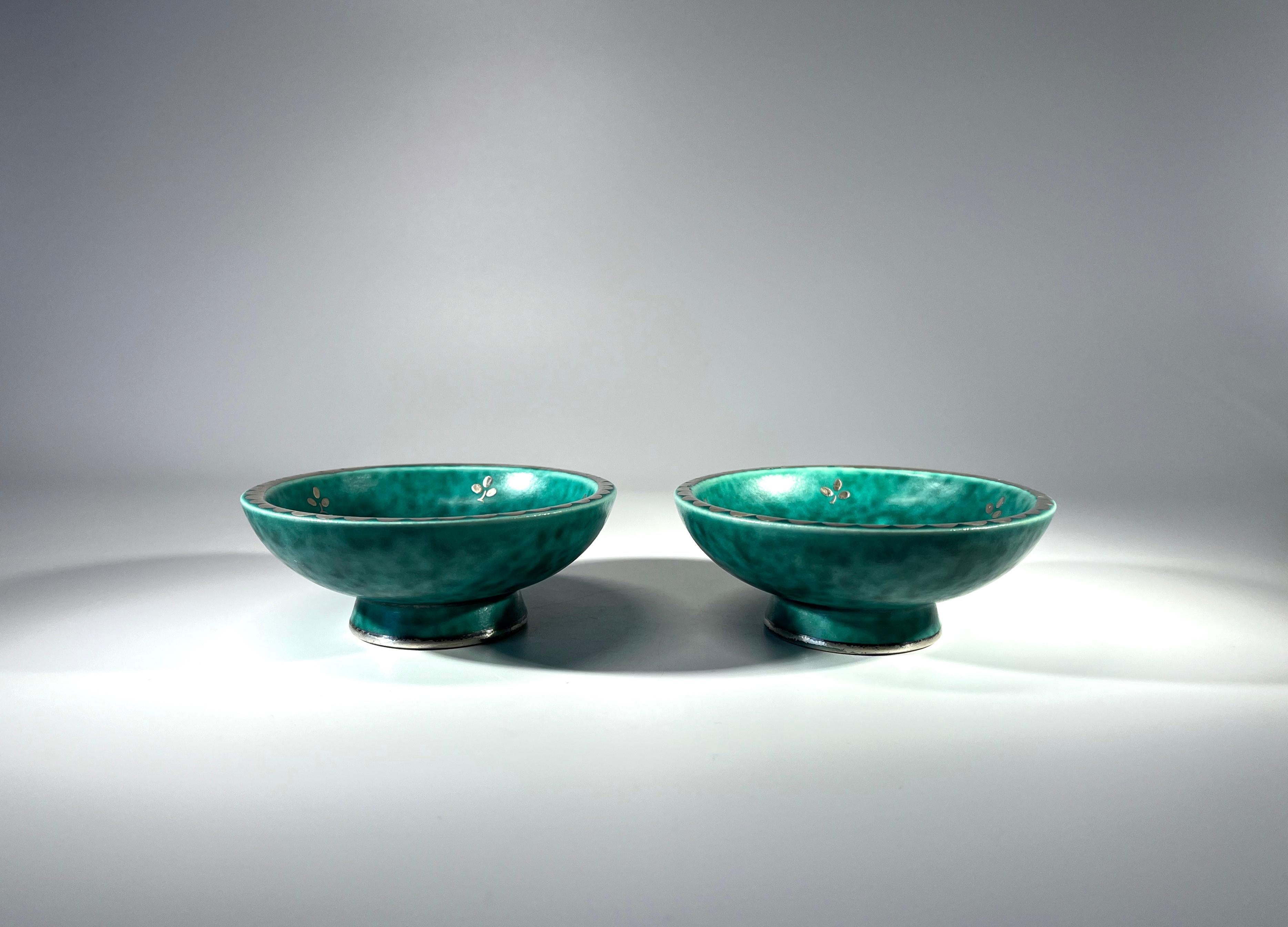 Pareja de pequeños platos Argenta de gres con pie, de Wilhelm Kage para Gustavsberg, Suecia.
Decorado con pequeñas ramitas de flores y borde festoneado en plata aplicada
Alrededor de 1959
Ambas piezas llevan el sello Gustavsberg Argenta  #1094 I M