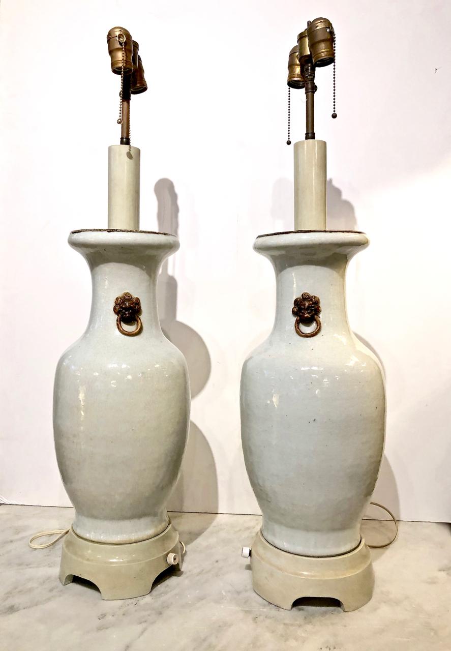 Dies ist ein hervorragendes Paar beeindruckender Lampen mit chinesischen Crackle Glaze Pale Celadon Vasen auf hohen elfenbeinfarbig lackierten Holzsockeln, ein Markenzeichen von Billy Haines Designs. Der typische Haines-Design-Elektroschalter