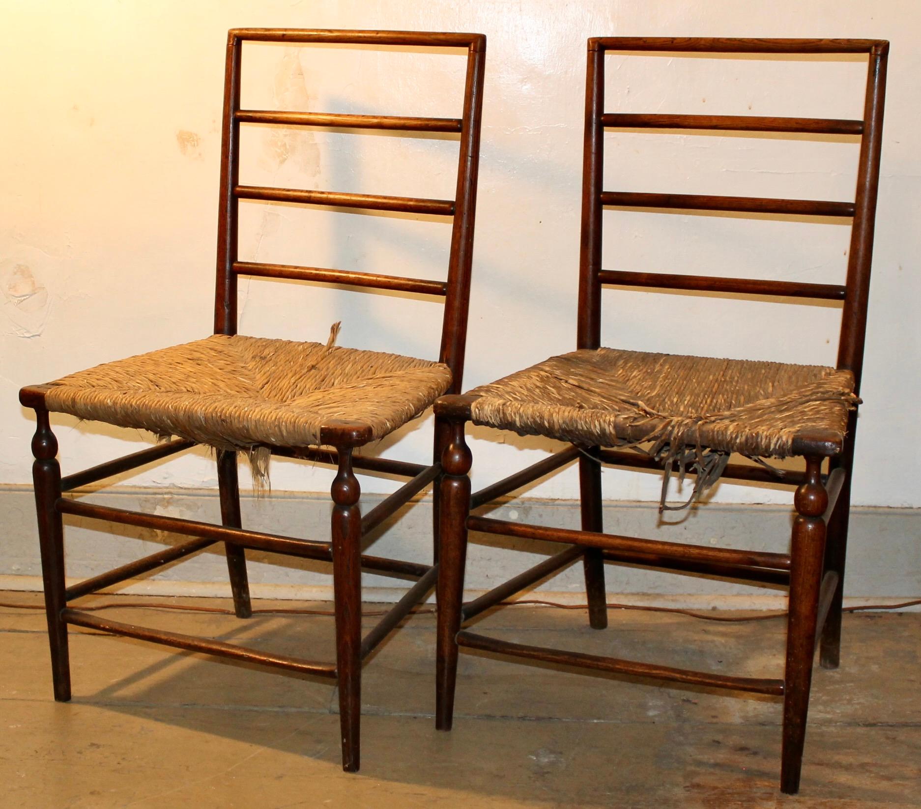 Pair of English Arts & Crafts Chairs, most likely Liberty & Co. and designed by
William Birch. Probably of Beech with 'Quaint' Rush seats. Circa 1900, but with unusually midcentury modern style backs, much like Robsjohn-Gibbings.