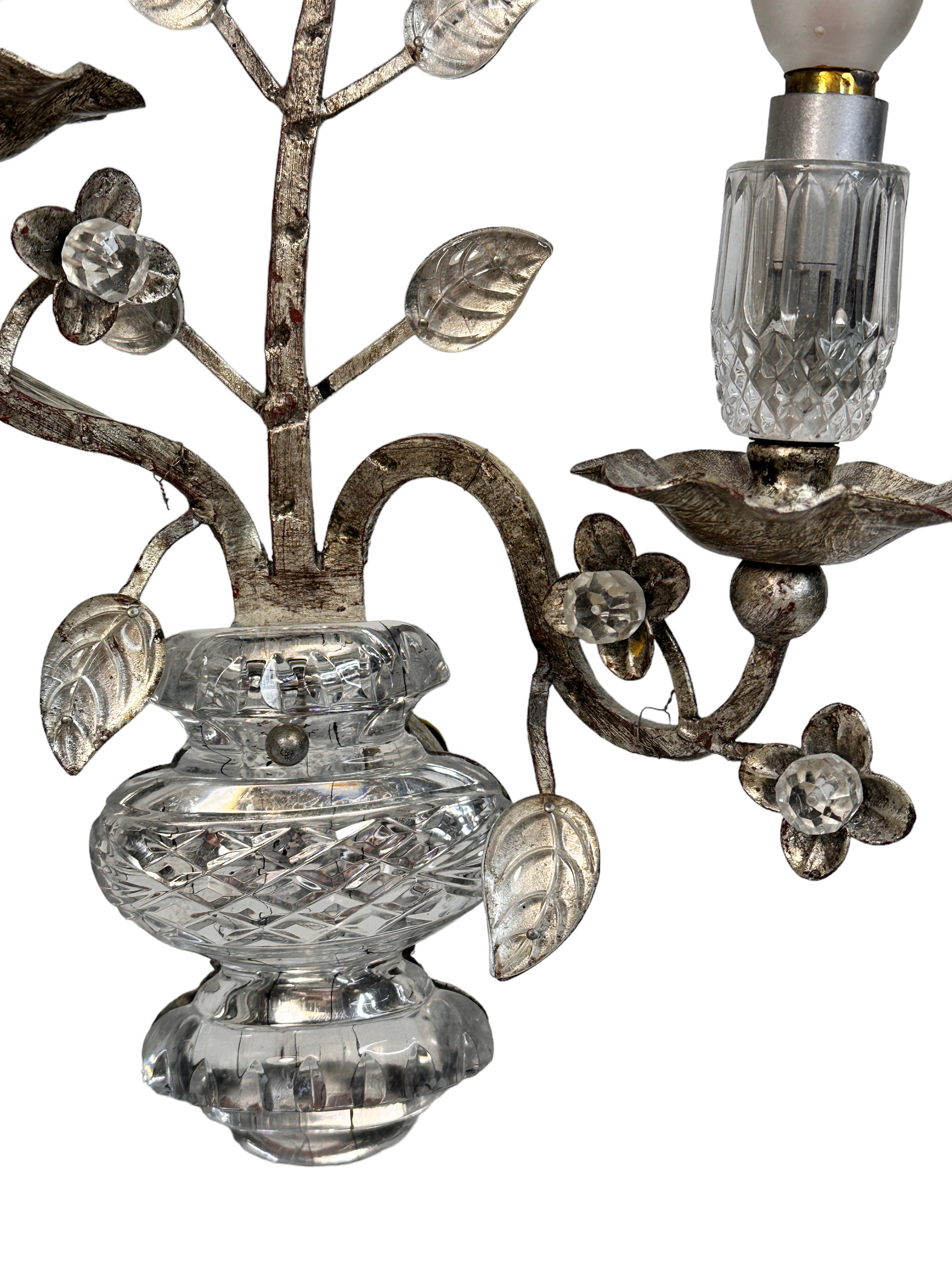 Pair of gilt iron floral sconces by Banci Firenze with crystal urn motif, socket cover also made of crystal glass. Each fixture requires two European E14 candelabra bulbs, each bulb up to 40 watts. The wall lights have a beautiful patina and gives