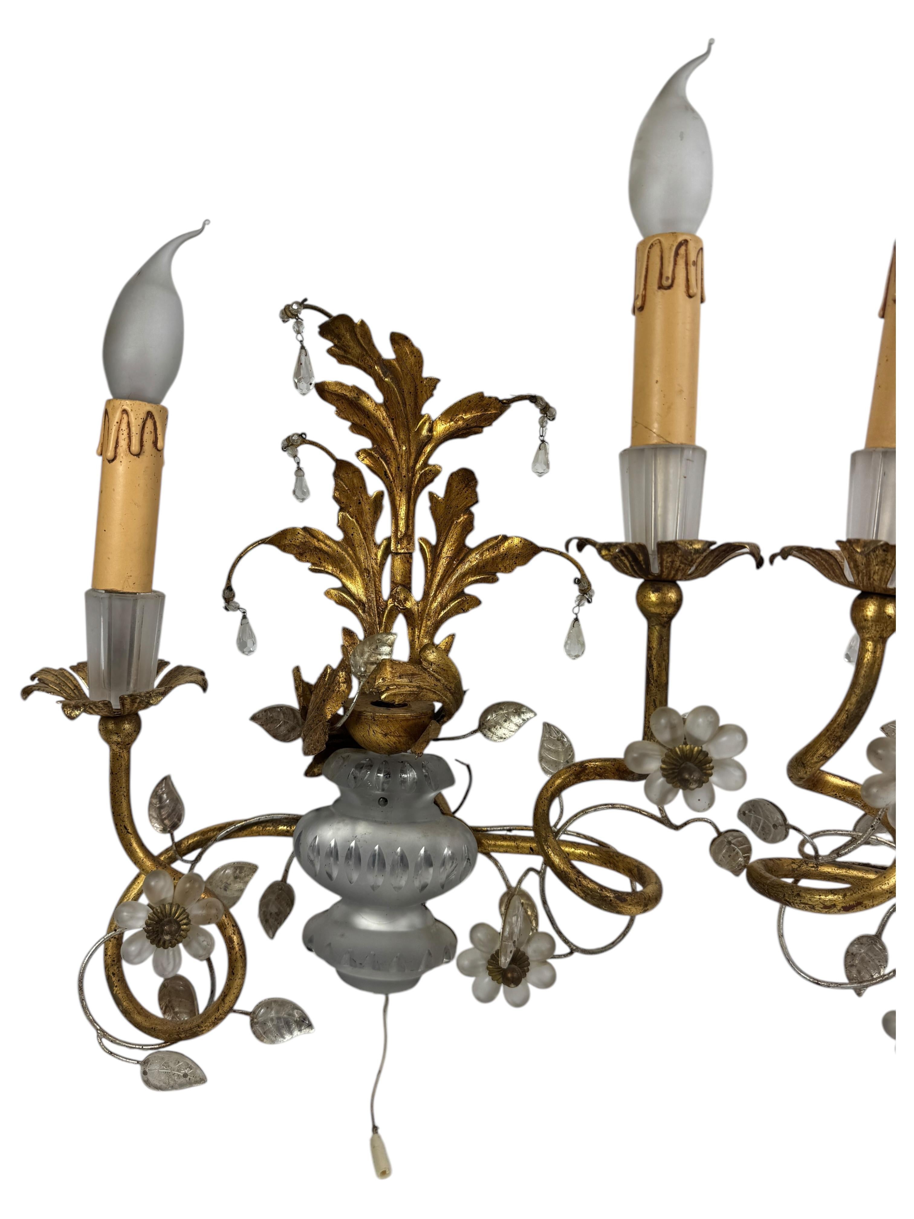 Pair of gilt iron floral sconces by Banci Firenze or Bagues with crystal urn motif, socket cover also made of crystal glass. Each fixture requires two European E14 candelabra bulbs, each bulb up to 40 watts. The wall lights have a beautiful patina