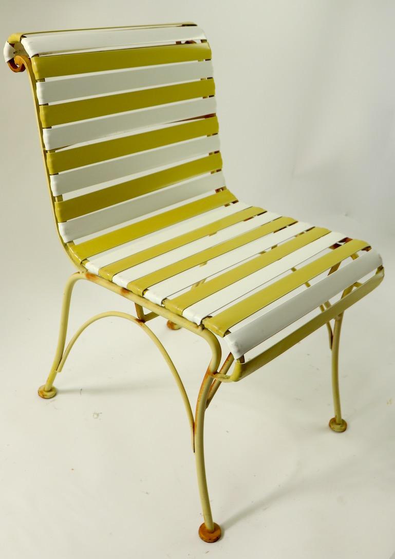 Stylish and chic lounge chairs by the Woodard Furniture company. These chairs have wrought iron frames with alternating yellow and white strap continuous seat and back. Perfect for Patio, garden or poolside use, showing only light cosmetic wear to