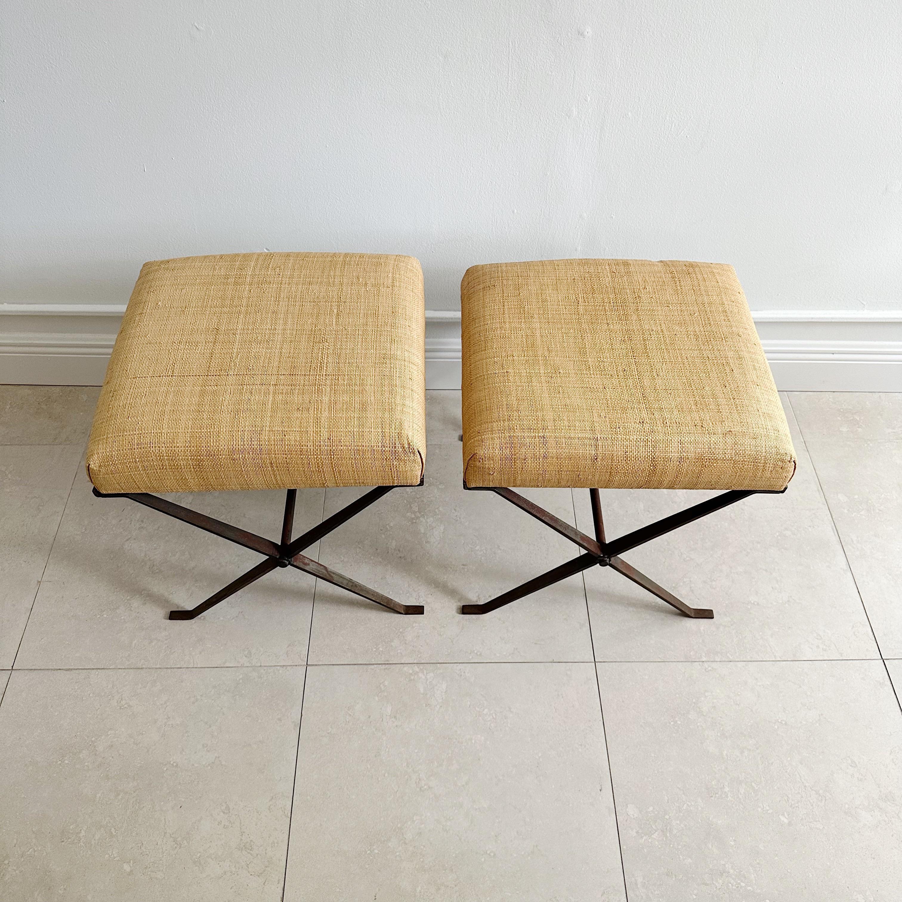 Pair of benches stools upholstered in a rattan fabric, the x bases in distressed steel. Unsigned
