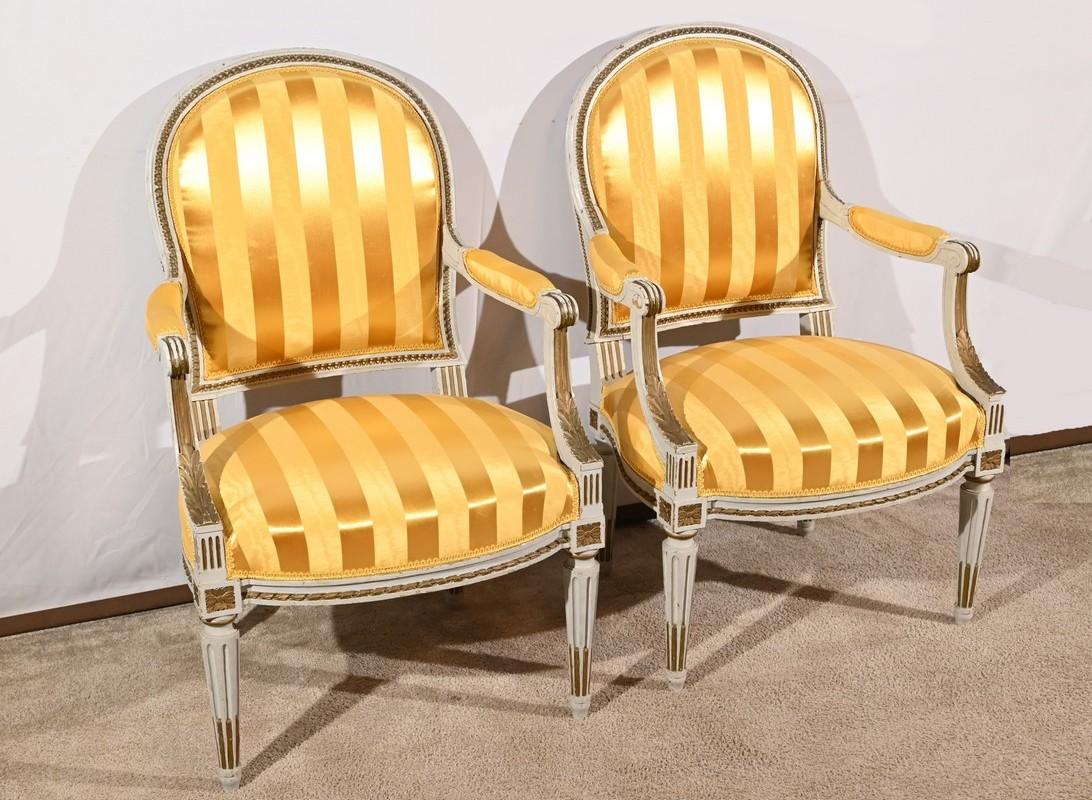 Elegante paire de fauteuils cabriolet, en bois ré-galvanisé, reposant sur des pieds tournés.
Les pieds antérieurs sont prolongés par des éléments concaves ornés de moulures en feuilles d'acanthe dorées supportant de petits accoudoirs à