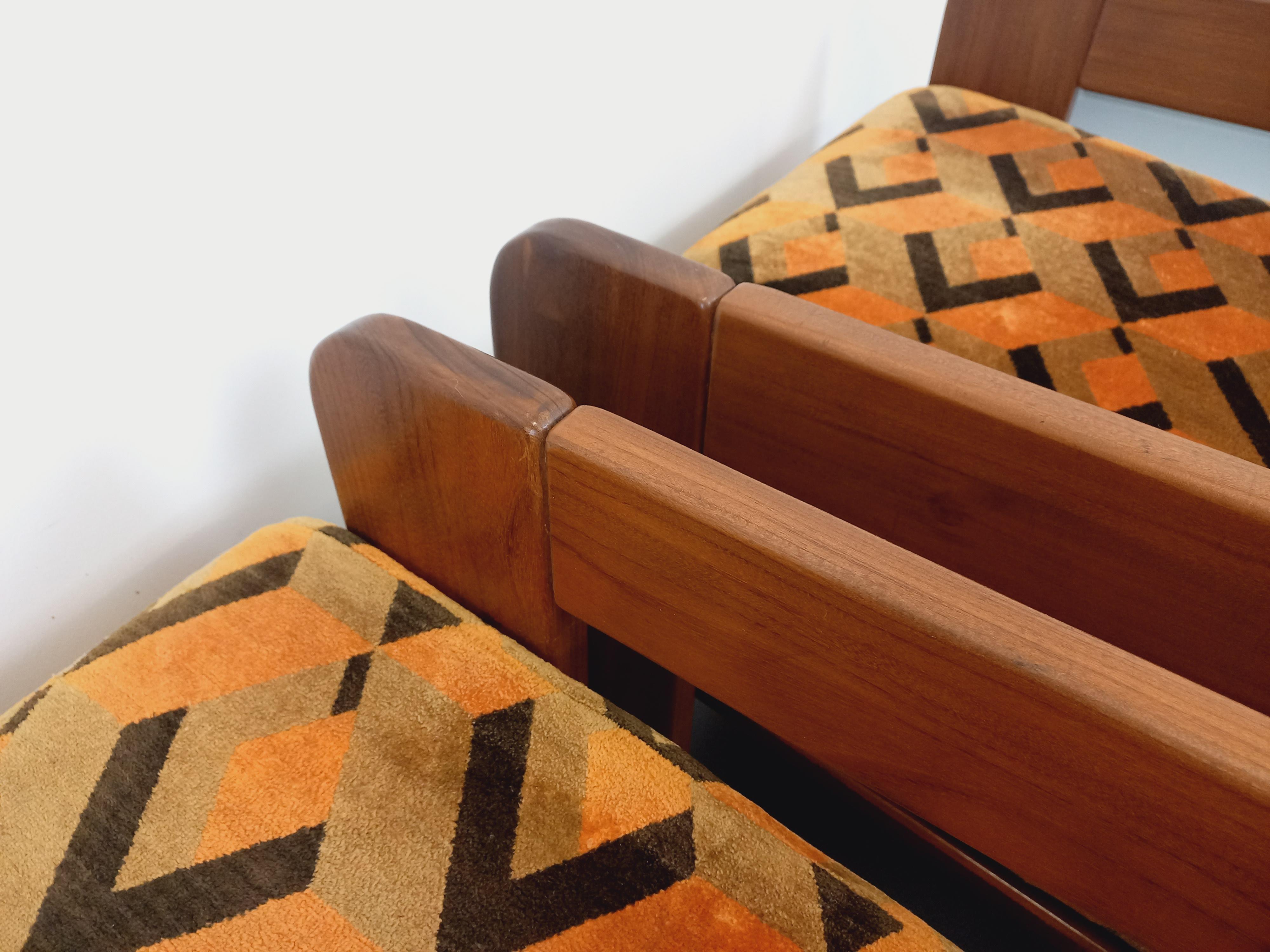 Suite de 2 fauteuils traîneau vintage des années 70, superbe design, notamment avec de magnifiques dossiers, en noyer, coussins amovibles pour les assises et dossiers, en tissu velours à motifs géométriques dans les tons orange, beige et noir.