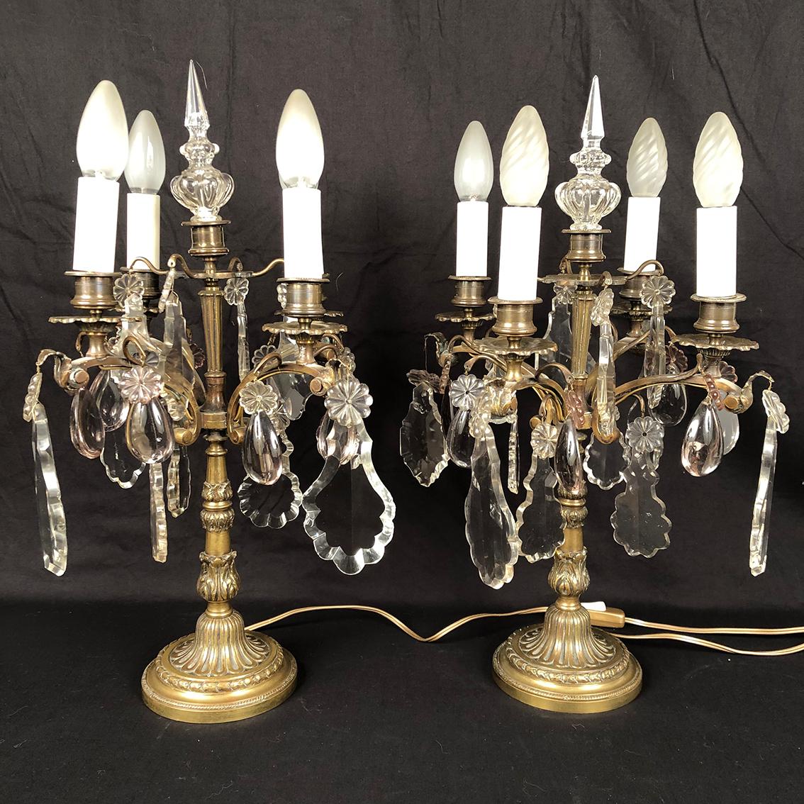 Paire de girandoles en bronze et pendeloques de verre à quatre bras de lumière, XXe
de style Louis XVI
Pendeloques de grande taille (une manquante) en verre transparent, pampilles en verre violine et poignards.
Fût ouvragé sur une base