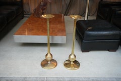 Paire de grands pique-cierges en laiton brossé reposant sur une base circulaire