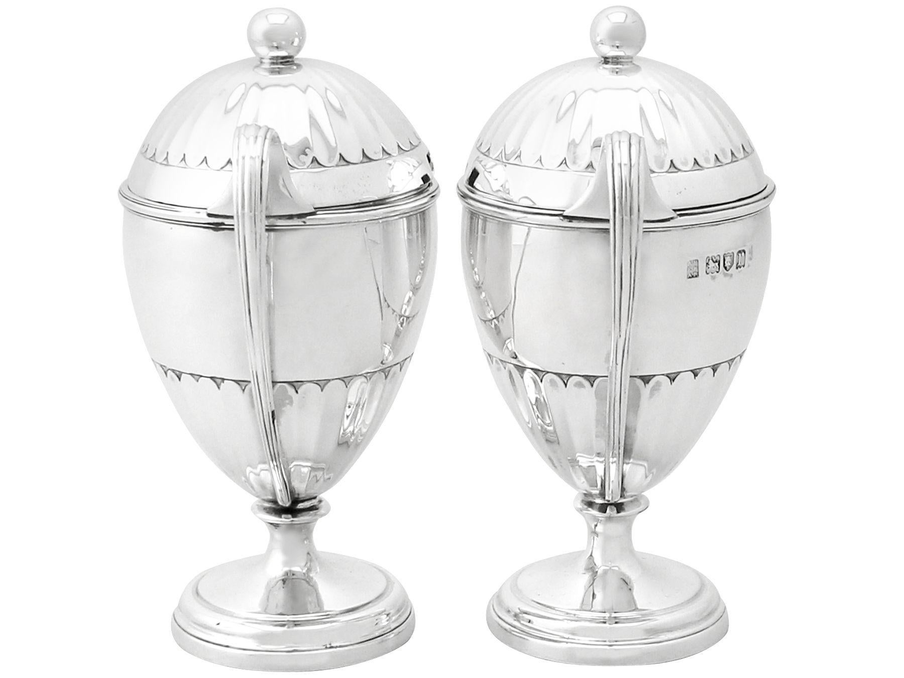 An exceptional, fine and impressive pair of antique George V English sterling silver preserve pots; an addition to our silver cruet and condiments collection.

These exceptional antique George V sterling silver preserve pots have a plain bell