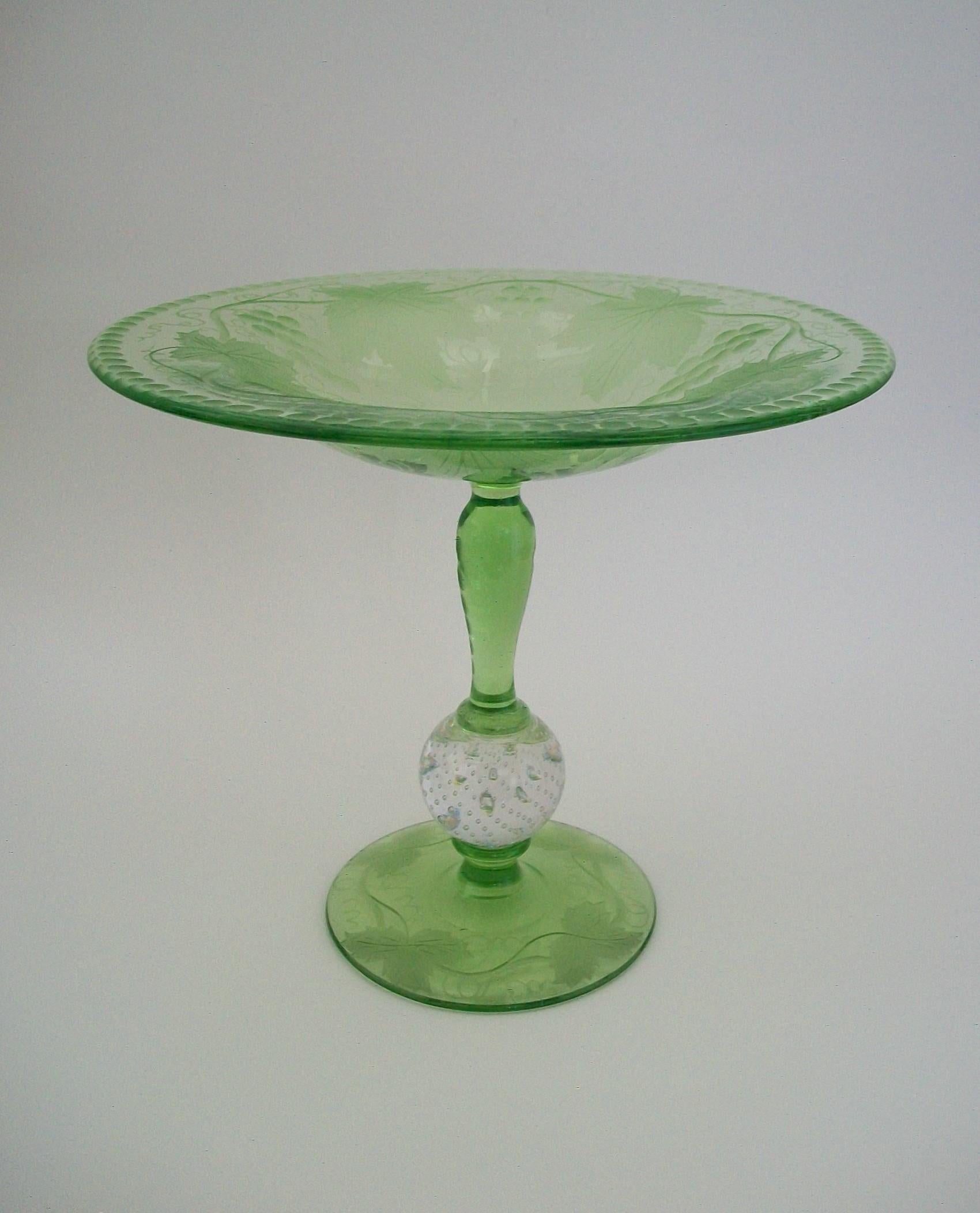 PAIRPOINT - Wheel etched green glass compote - featuring etched grapes, grape leaves and meandering vines to the bowl and base - etched stem and rim - central 'controlled bubble' knop in clear glass - polished finish throughout - unsigned - United