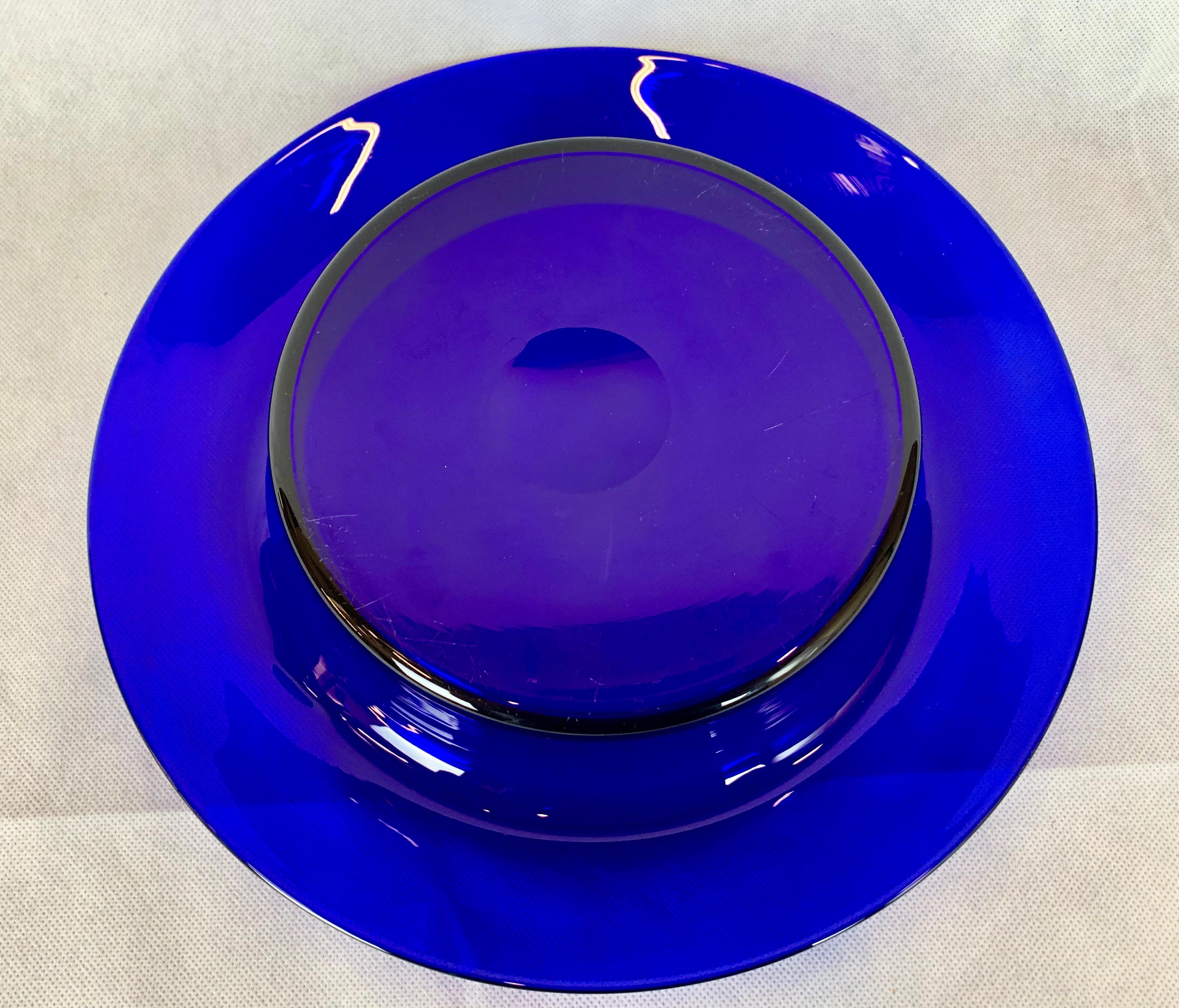 Pairpoint type cobalt blue glass bowl with everted rim. This piece has been hand blown and is evidenced by the polished pontil on the base. These bowls were popular in the United States from 1900-1930. The bowl has been photographed on a white