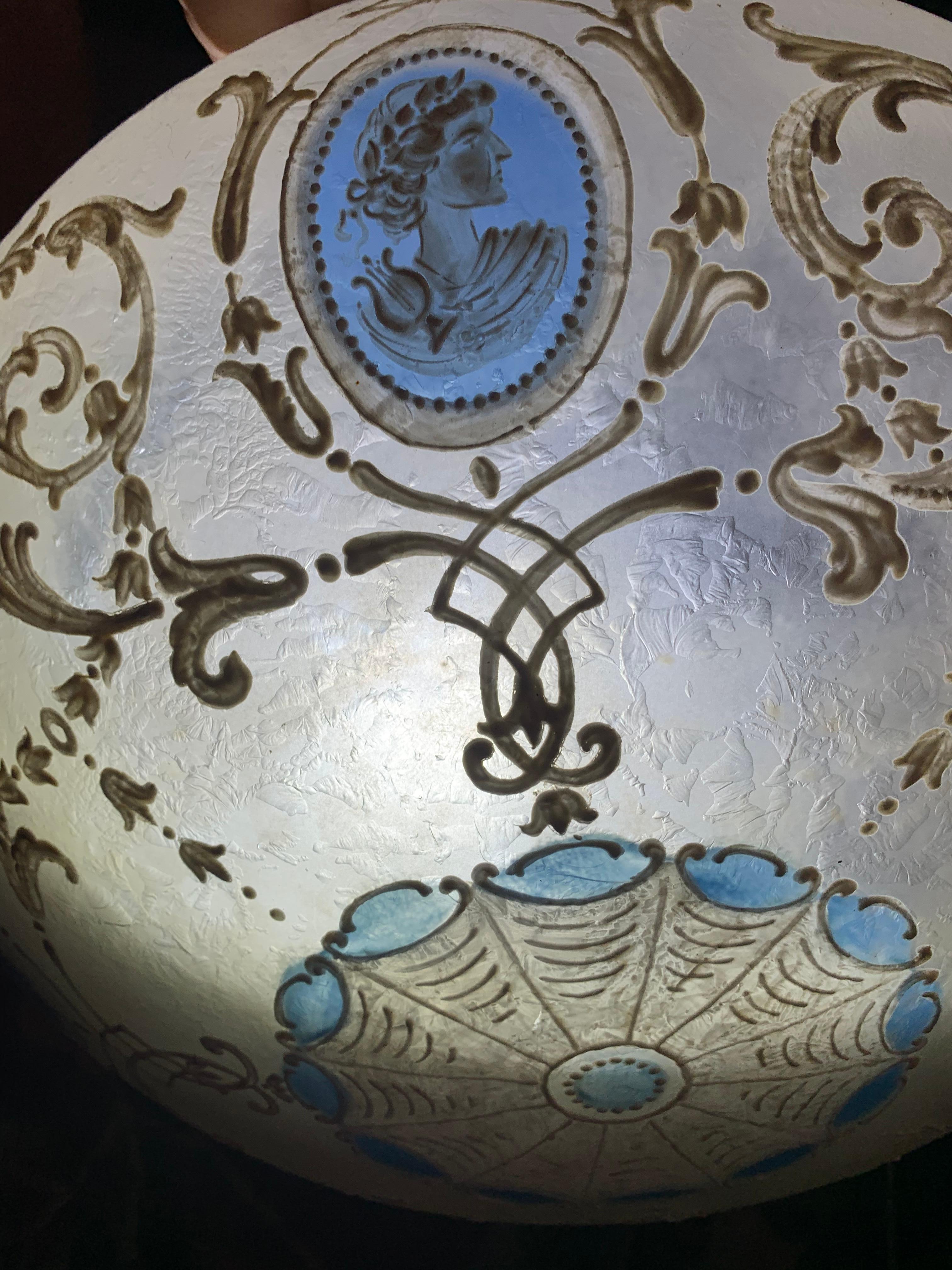 Lustre néo-classique bleu wedgewood peint à la main, années 1920.
Lustre de plafond avec des chaînes en laiton et une fixation présentant une décoration Wedgwood avec un contour en émail blanc à l'extérieur. Abat-jour de Vienne, signé.
Provenance :