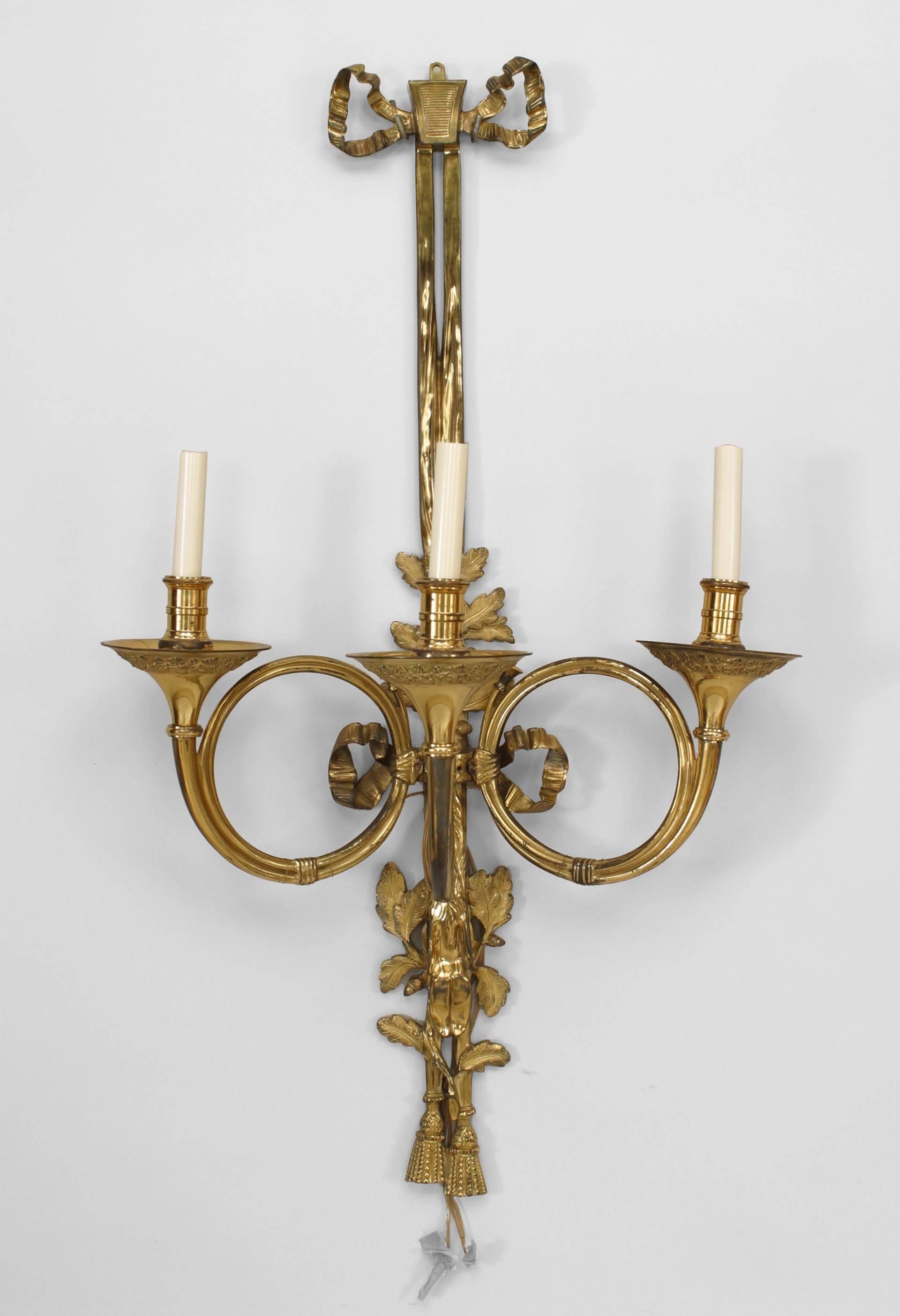 7 French Louis XVI-style (20th Century) bronze dore wall sconces with three horn-shaped arms, bow knot tops and tassel bottoms. (PRICED EACH)
