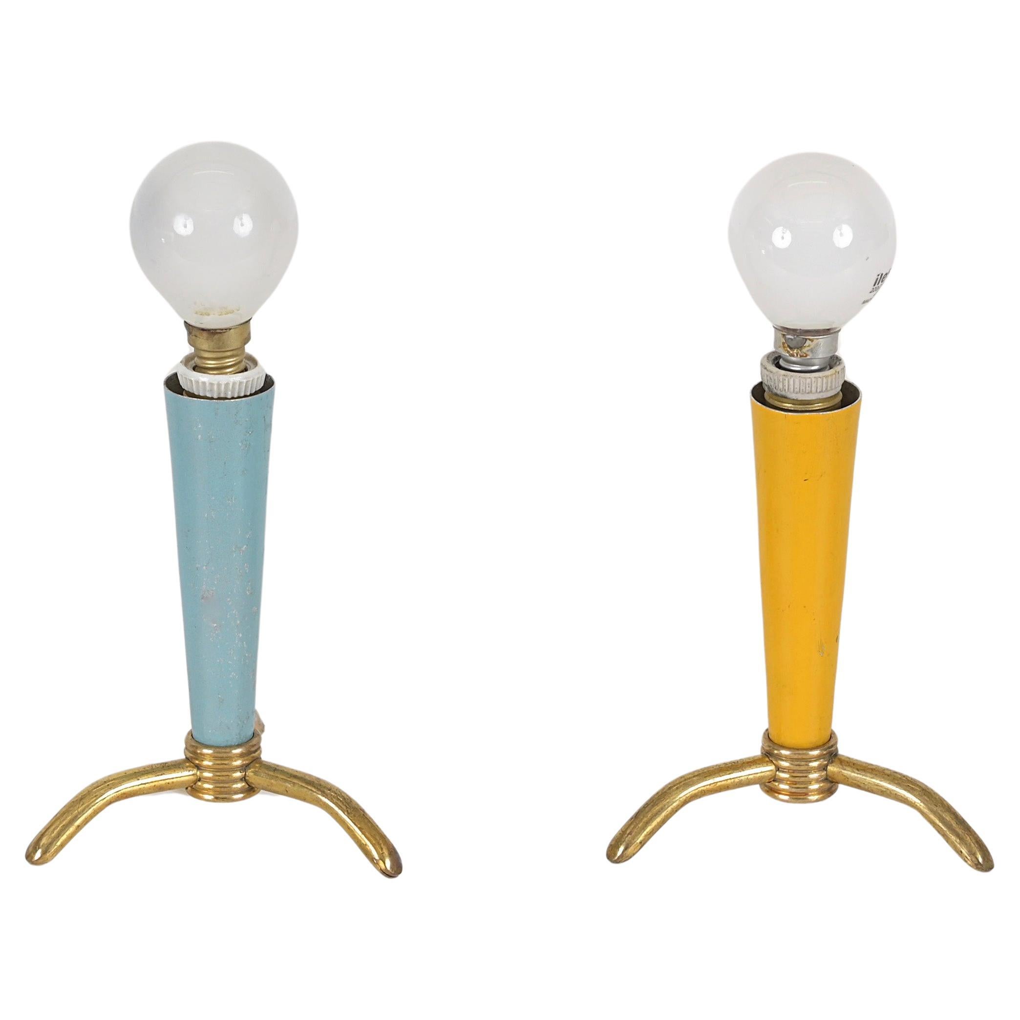 Charmantes Paar dreibeiniger Tischlampen aus Messing und emailliertem Metall. Diese schönen Lampen werden Stilnovo zugeschrieben und wurden in den 1950er Jahren in Italien hergestellt.

Die kleinen Lampen haben einen reizvollen kegelförmigen Schirm