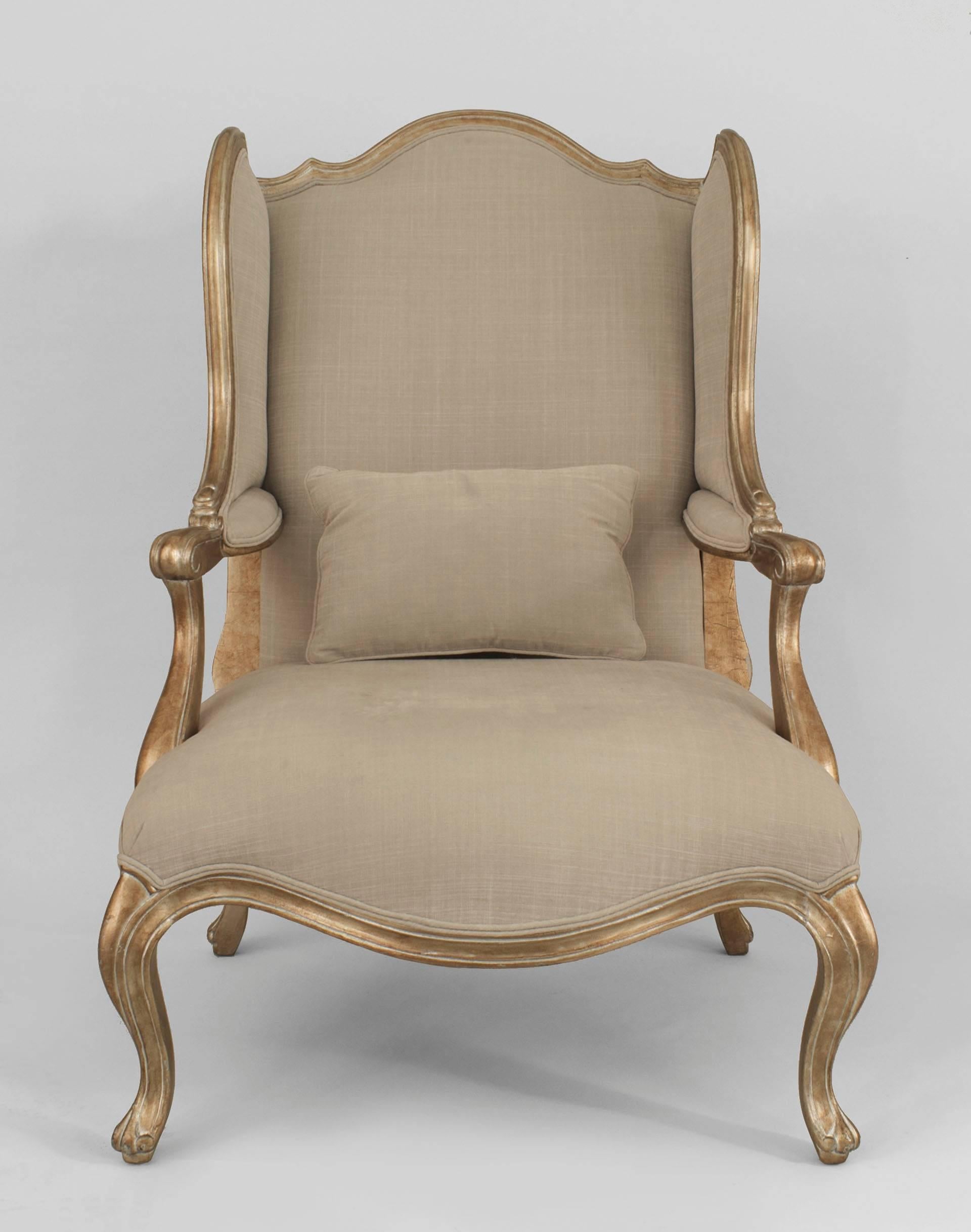 Pair of Louis XV-style vintage gilt wing form open arm bergere chairs with beige upholstery and a lower seat cushion (PRICED AS Pair)
