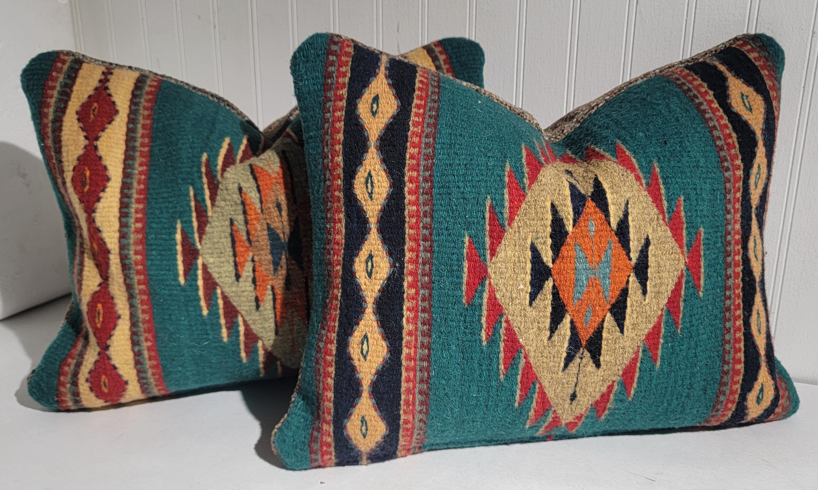 2 pairs of Mexican Indian wool pillows with thick linen golden brown backing. Each pillow has its difference in color pallet to the center eye. Pairs are sold at random. Random pillows will be chosen at sale. 