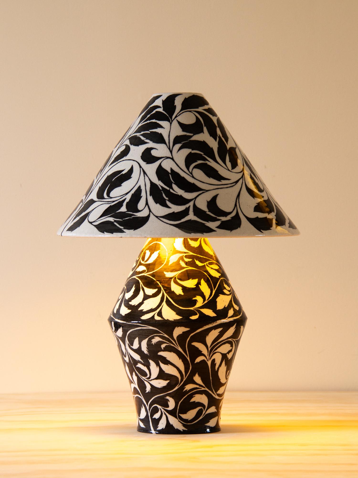 Each Paisley Lamp is meticulously handcrafted—thrown in parts on the potter’s wheel and carefully assembled. The surface is hand-painted with a swirling botanical design. The leaves and vines, painted in black against a white background (and vice