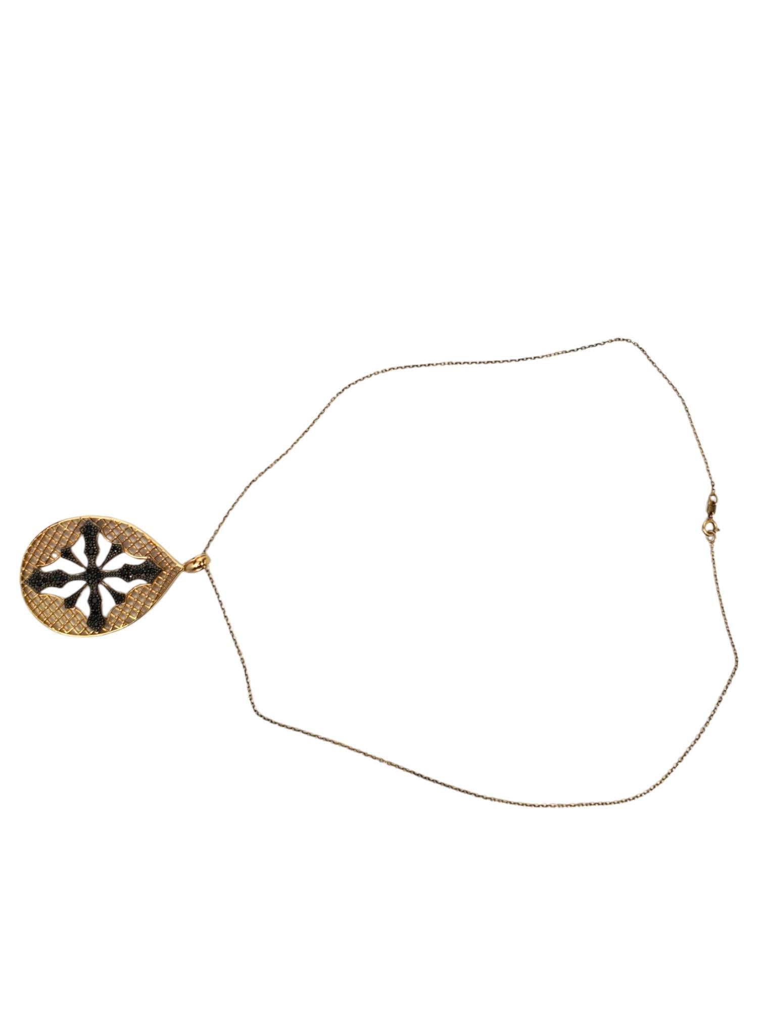 PAJ Sterling Silber Gold-Ton Schwarzer Stein Kreuz Anhänger Halskette -

Dieser auffällige, tropfenförmige, goldfarbene Anhänger zeigt ein Kreuz aus schwarzen Steinen mit einem Gitterhintergrund, der von PAJ in Sterlingsilber an einer 18 Zoll langen