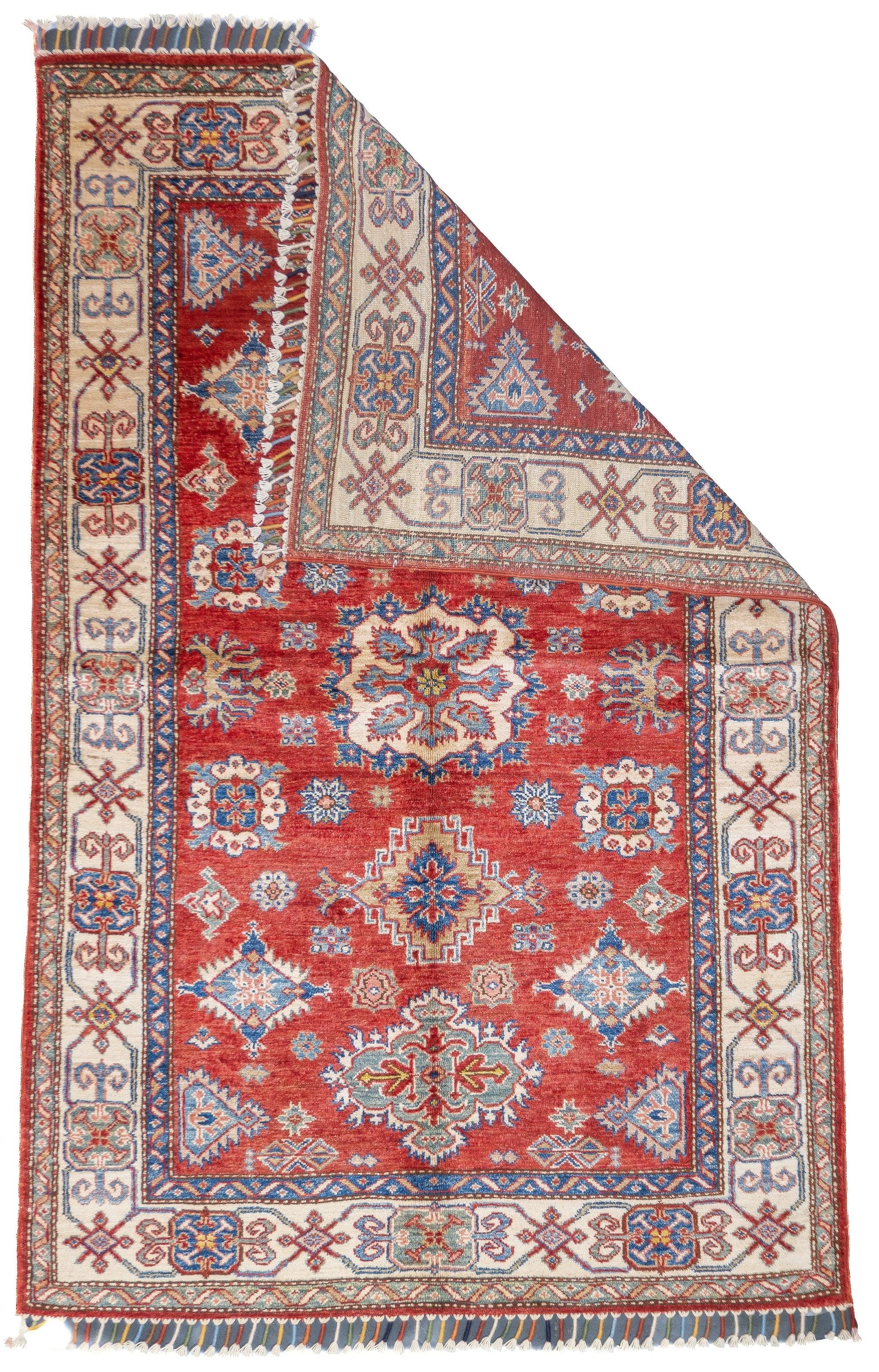PAK Kazak Rug 3'10'' x 5'11''. Pakistani post-WWII rug, generally scatters, with soft wool and curvilinear Persianate designs. Synthetic dyes, cotton foundations. Moderate to medium weaves.