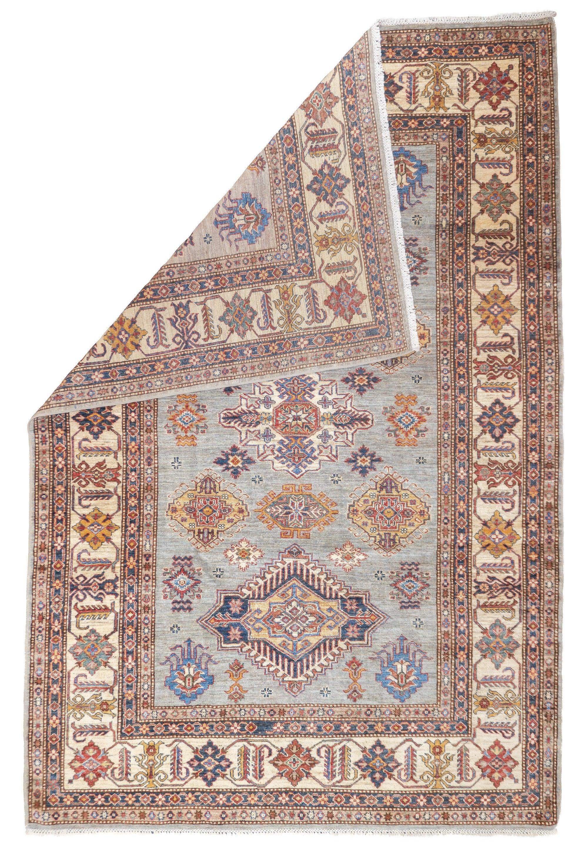 PAK Kazak Rug 6'2'' x 9'3''. Pakistani post-WWII rug, generally scatters, with soft wool and curvilinear Persianate designs. Synthetic dyes, cotton foundations. Moderate to medium weaves.